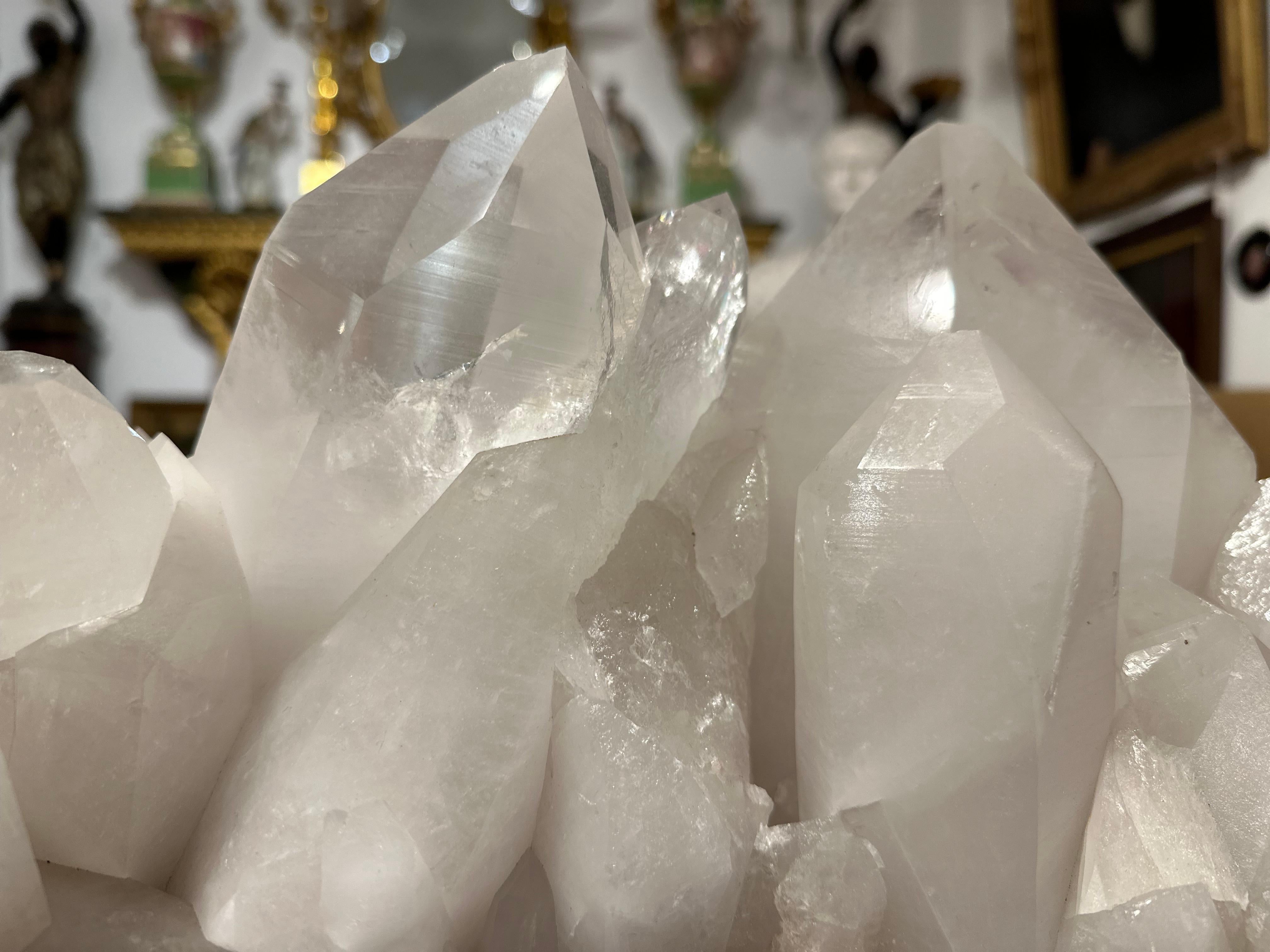 A highly decorative and dazzling natural rock crystal quartz cluster on a black stand. A excellent and rare example of rock crystal, a crystal that is associated with balance, energy and clarity and credited with benefiting ones health and spiritual