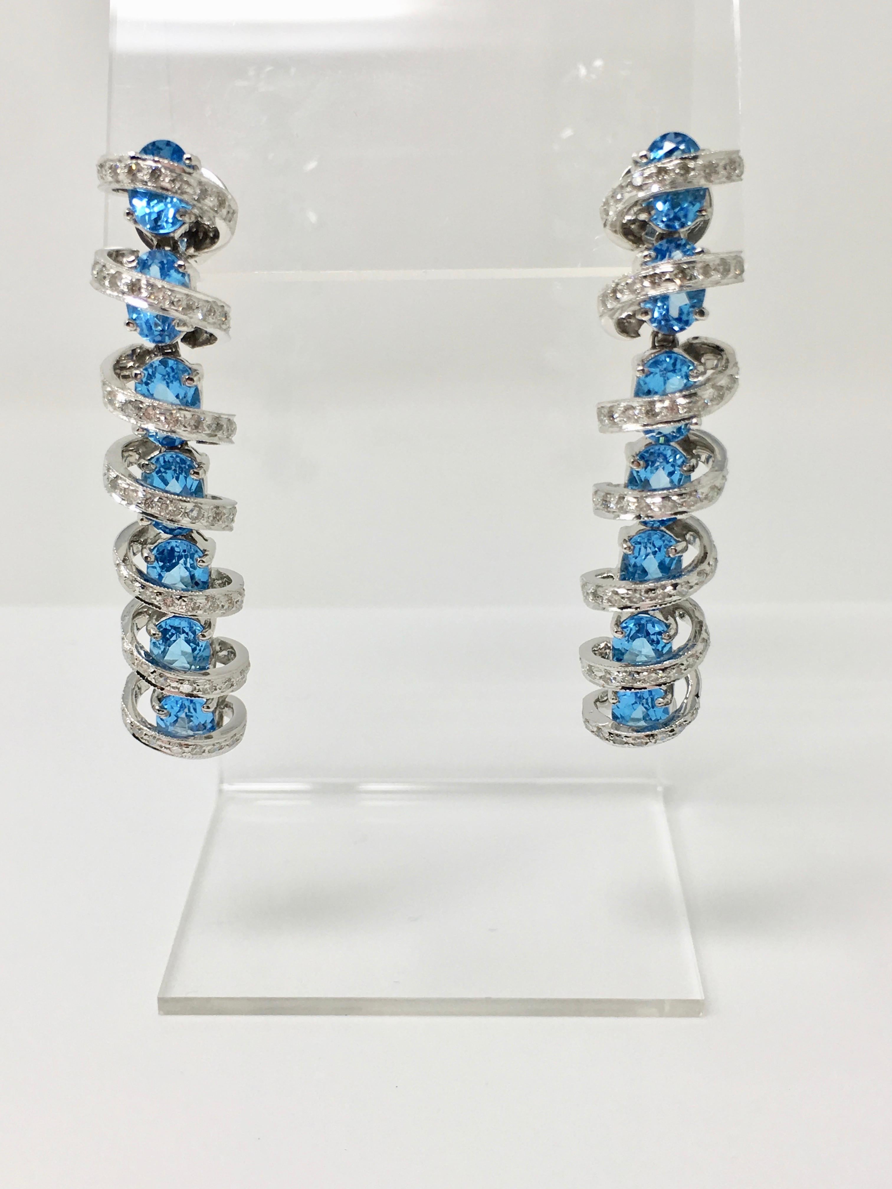 This unique white round brilliant diamond and blue topaz pendant set is beautifully custom hand made in 18k white gold. The white round brilliant diamond weighs 3 carats approx and oval blue topaz weighs 26 carats approx. The length of the earrings