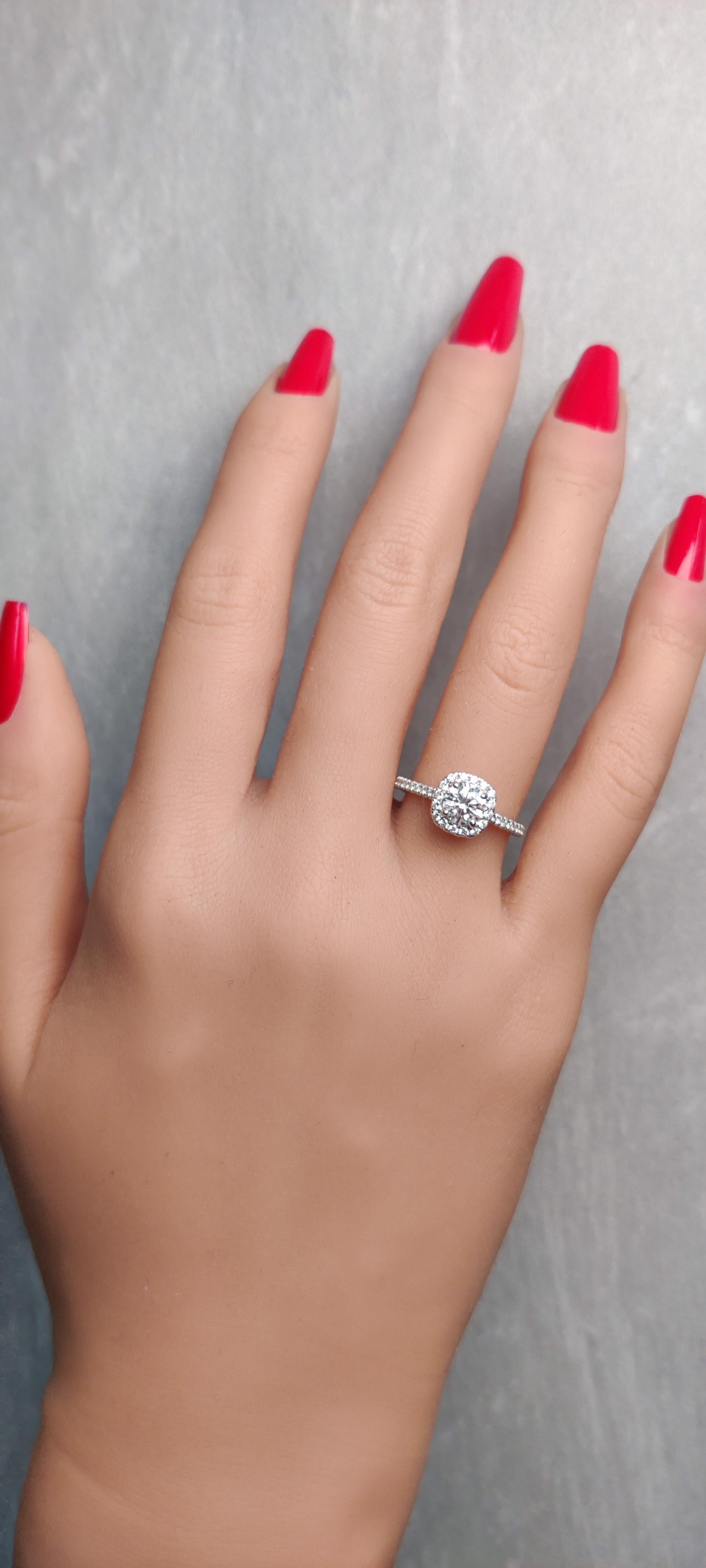 Der klassische Diamantring von RareGemWorld. In einer schönen Fassung aus 18 Karat Weißgold mit einem großen weißen Diamanten im Rundschliff, umgeben von runden weißen Diamanten im Nahbereich. Dieser Ring wird Sie garantiert beeindrucken und Ihre