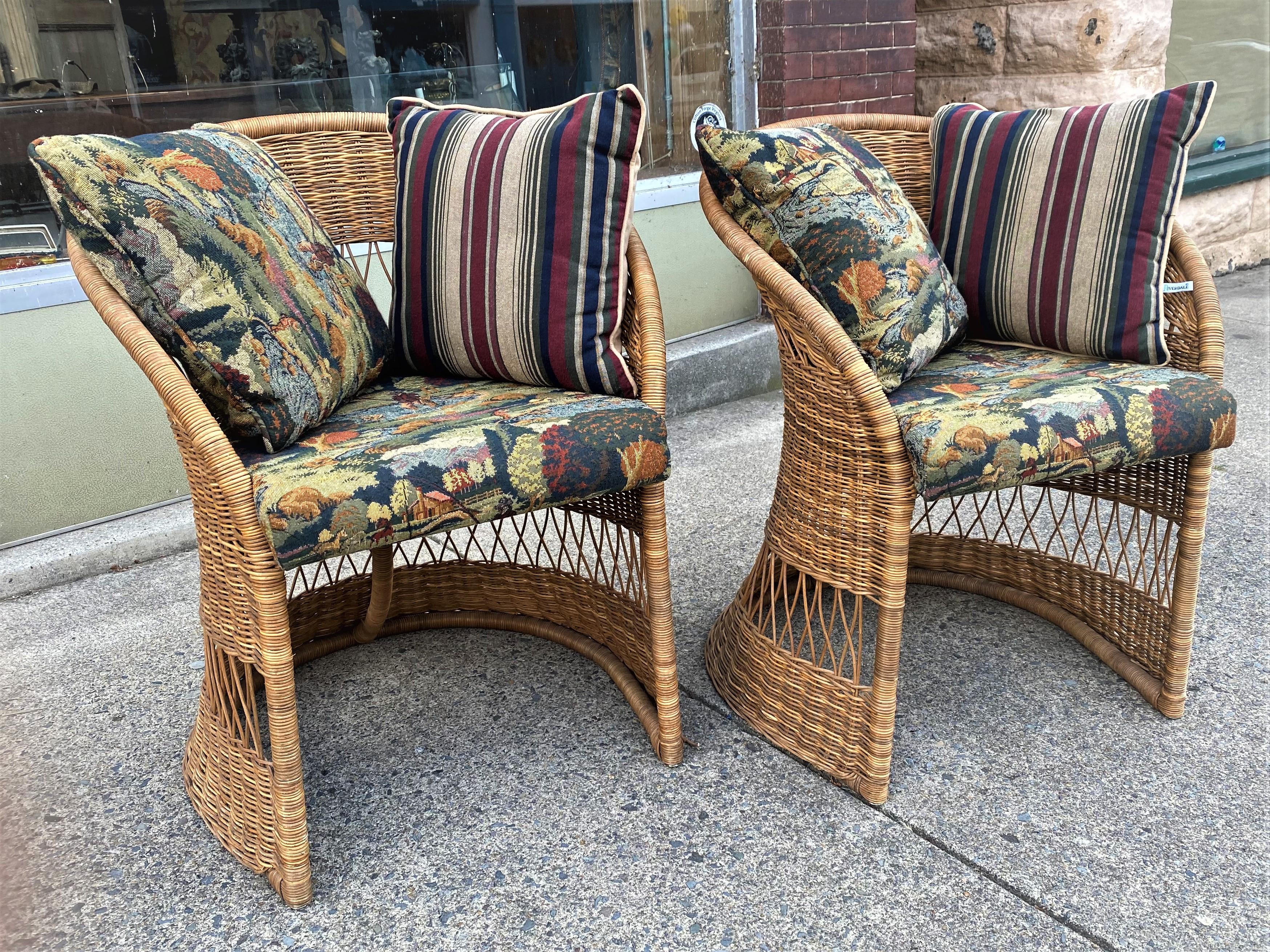 Here are a sweet pair of natural wicker occasional chairs in an appealing mid century tulip or barrel design with an open base and openwork around the outside of the base and the midsection. The seats have been upholstered in fishing pattern
