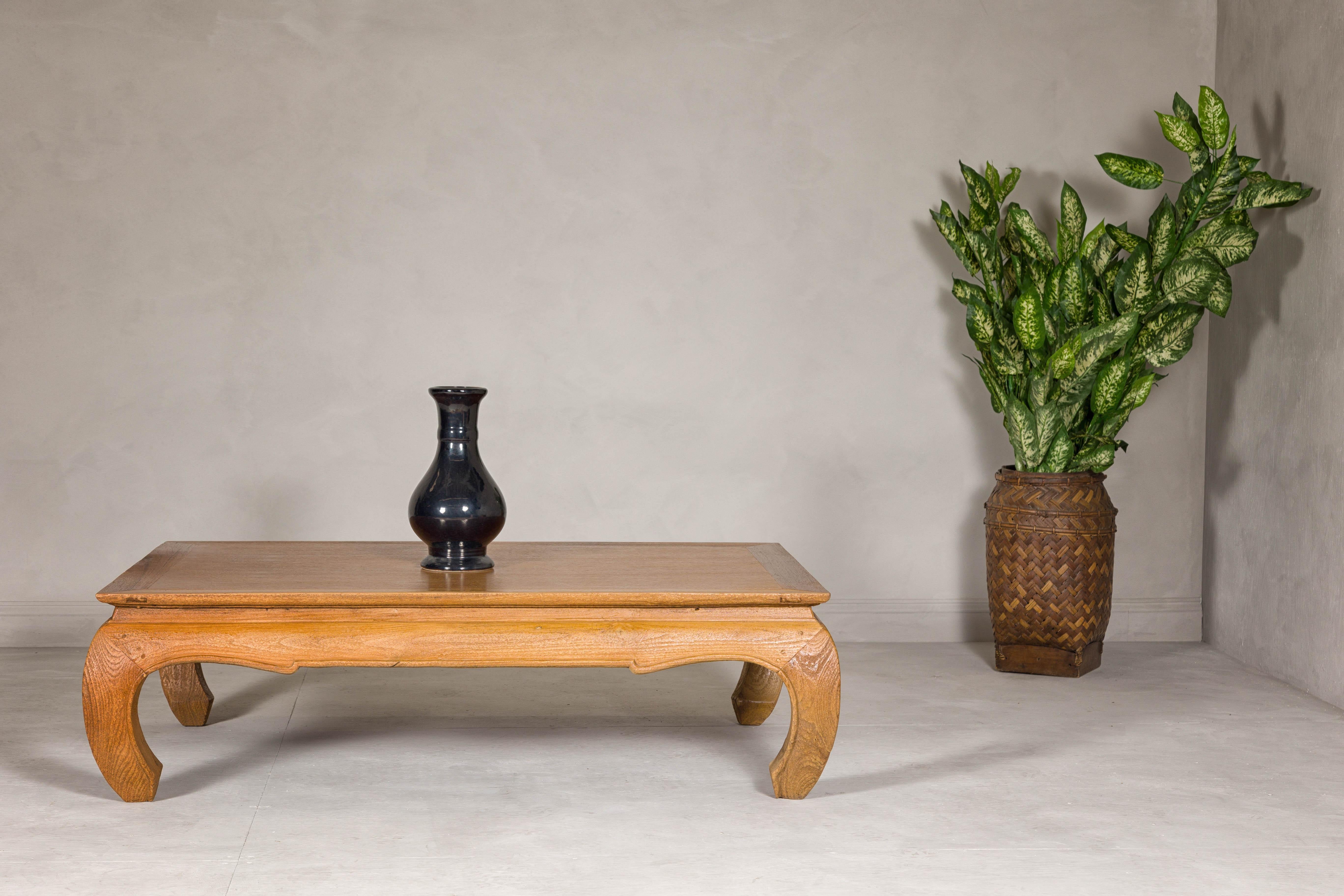 A Chow leg coffee table with waisted and carved apron and natural wood patina. This vintage Chow leg coffee table, expertly restored and refinished, exudes a timeless elegance with its natural wood patina and refined craftsmanship. The table