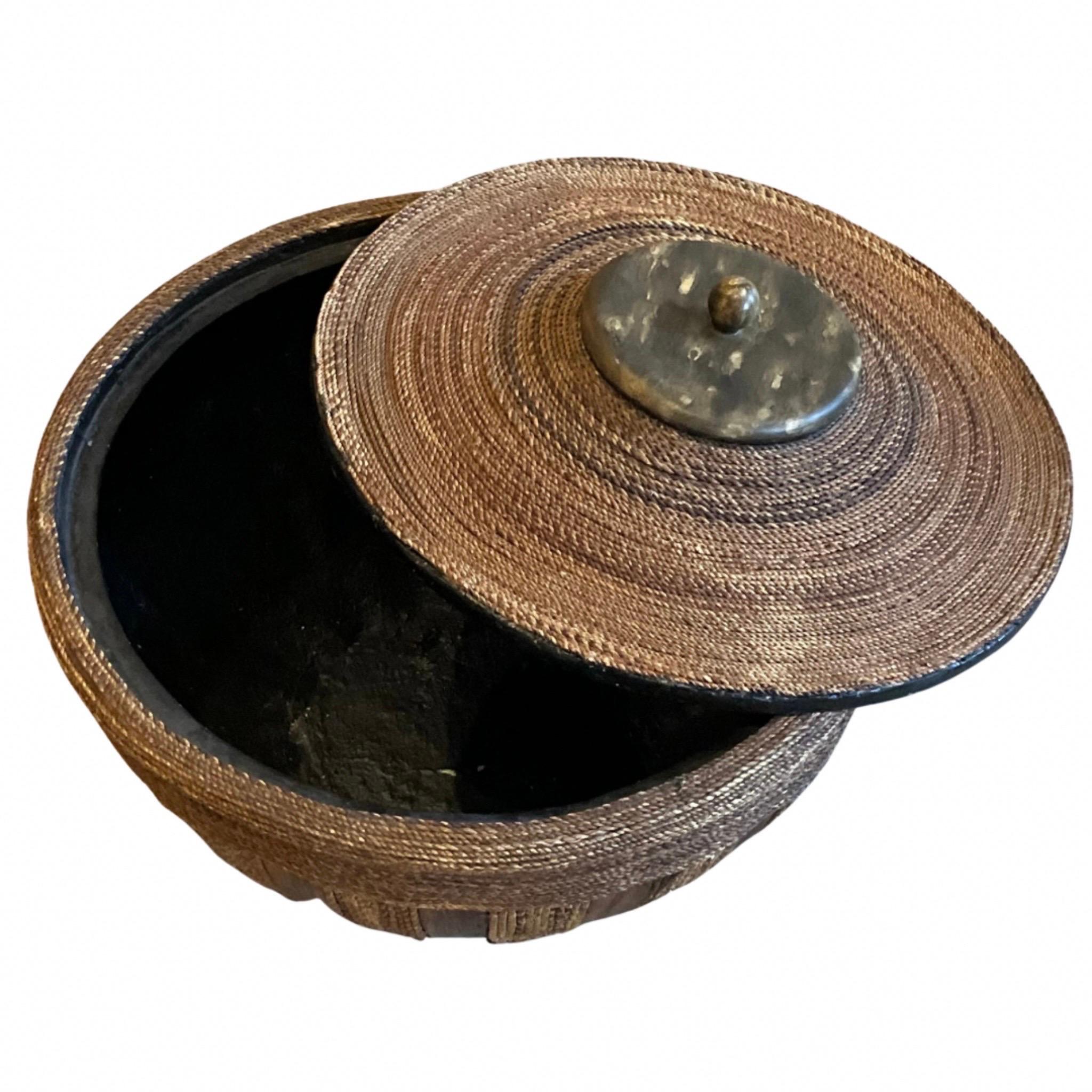 Beautiful natural woven fiber basket, bowl, container with lid

Curved wood strips accent on the sides

Resin lid with ball handle

Black fiberglass lining.