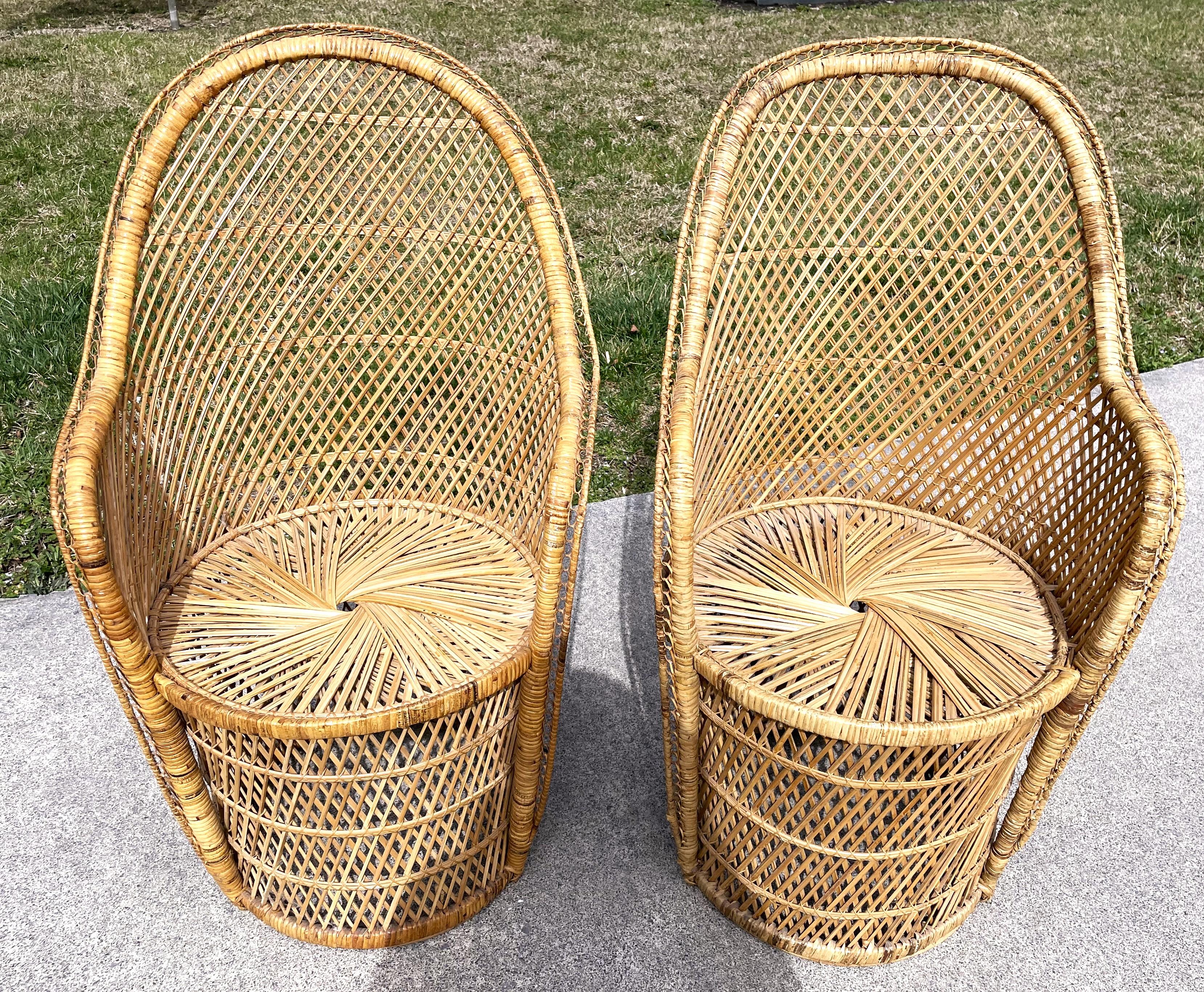 This is a wonderful boho chic pair of rattan chairs with natural wicker woven in a conventional cross hatch pattern. The chair bottoms are round like barrels and the tops are a flared barrel shape. I think these chairs have always been a pair but