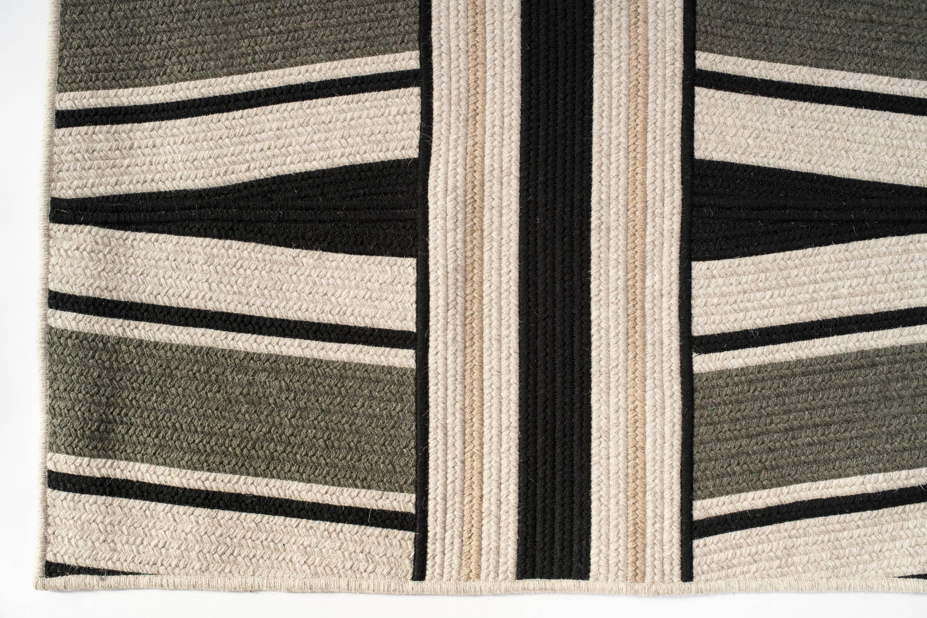 Our Studio Woven Wool Rug in Moss Green & Black wool is designed in our Boston Studio and custom crafted in Rhode Island USA. Angled lines and use of color create pattern in our Studio Rug. Black and moss wool blend yarns are grounded with light