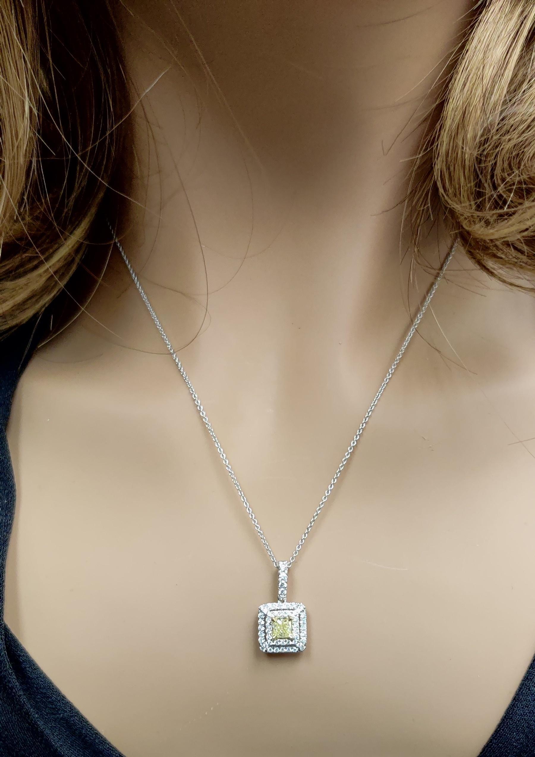L'intriguant pendentif en diamant de Raregemworld. Monté dans une belle monture en or jaune et blanc 18 carats avec un diamant jaune naturel de taille coussin. Le diamant jaune est entouré d'une mêlée de diamants blancs ronds naturels. Ce pendentif
