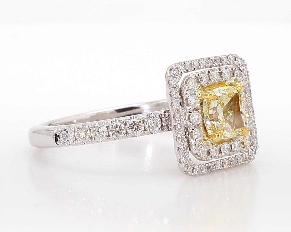 RareGemWorld's classic diamond ring. Mounted in a beautiful 18K Yellow and White Gold setting with a natural cushion cut yellow diamond. The yellow diamond is surrounded by round natural white diamond melee. This ring is guaranteed to impress and