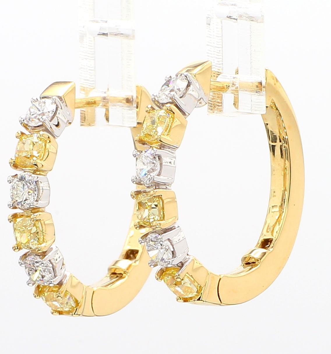 Les magnifiques boucles d'oreilles en diamant de Raregemworld. Monté dans une belle monture en or jaune et blanc 18 carats avec des diamants jaunes naturels de taille coussin. Les diamants jaunes sont entourés d'une mêlée de diamants blancs ronds