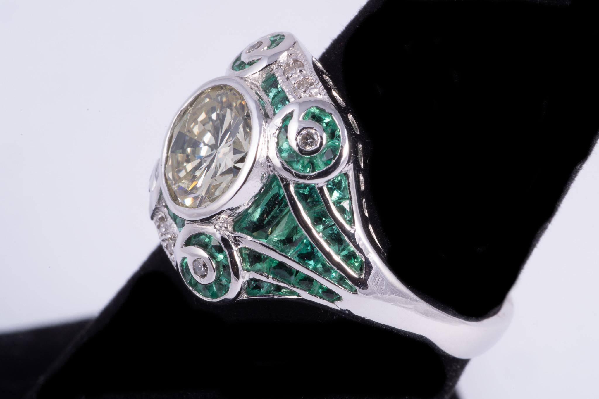 This ring features and 1.41ct natural yellow round brilliant cut diamond. The ring is accented by calibre cut emeralds and full cut diamonds weighing approx. .05cts. Set in platinum, 6.00grams. Size 6.5 and is sizable.
