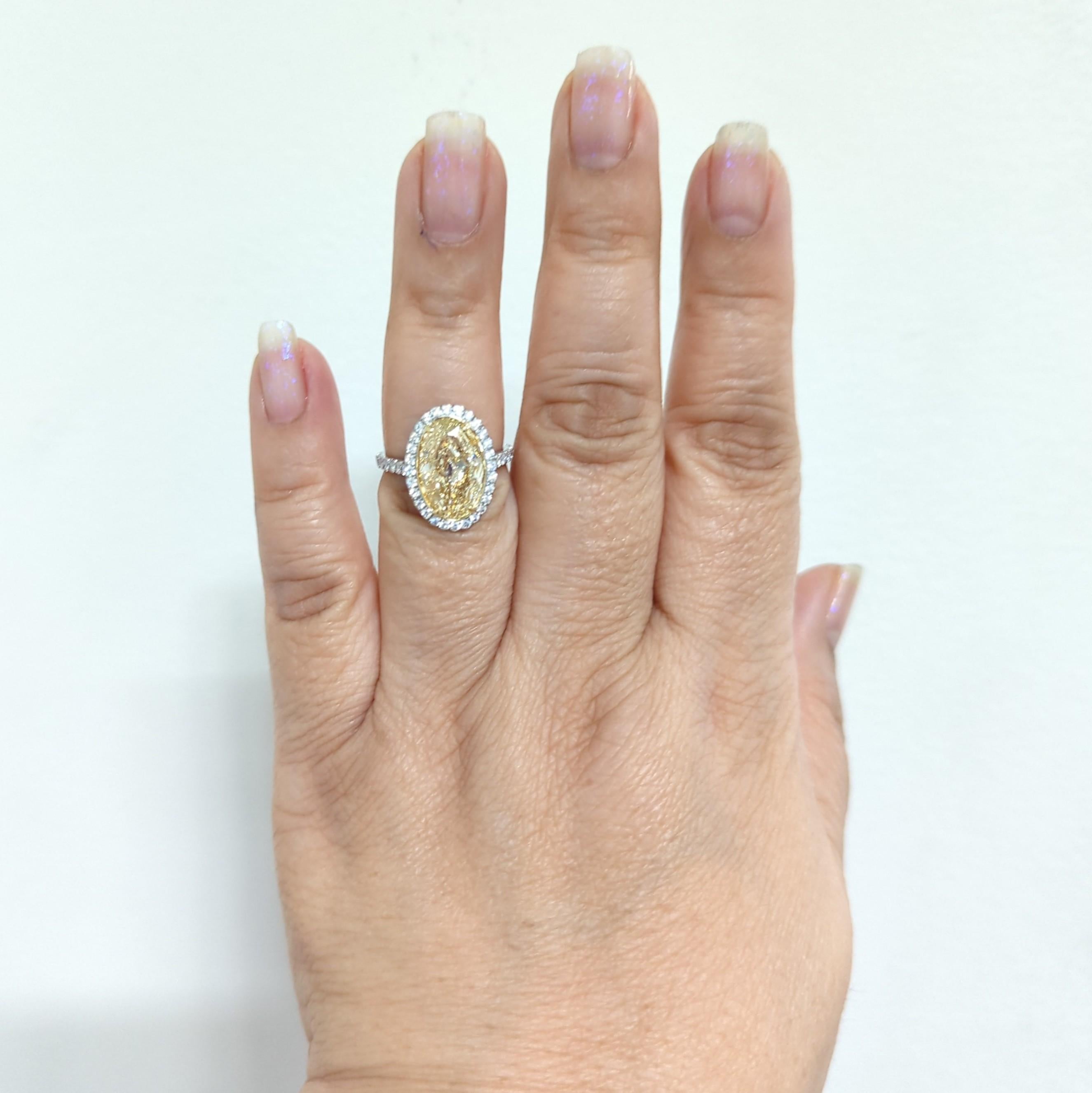 Gorgeous 5.01 ct. natural yellow diamond oval with 0.85 ct. good quality white diamond rounds.  Handmade in 18k white and yellow gold.  Ring size 6.5.  This ring is stunning in person.  There are no certificates but an appraisal can be provided.