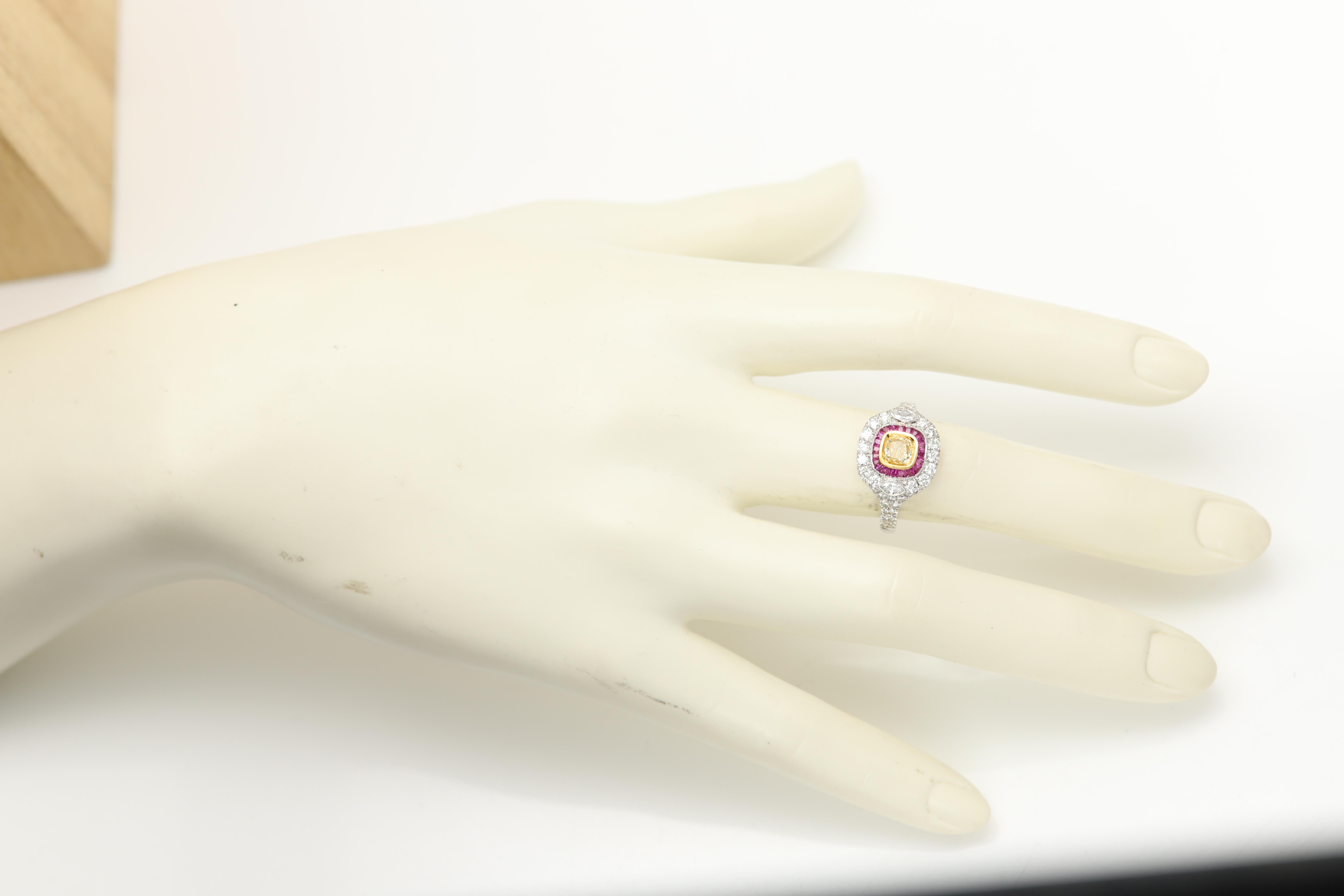 Style Art Déco 
Bague de déclaration très audacieuse
Le centre est constitué d'un diamant jaune naturel entouré d'un rubis rouge. 
Tous les côtés sont ornés de diamants blancs sertis en grappe.
Toutes les pierres sont naturelles
Or blanc 18k poids
