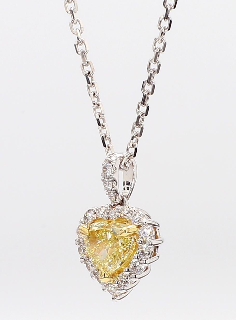 L'intriguant pendentif en diamant de Raregemworld. Monté dans une belle monture en or jaune et blanc 18 carats avec un diamant jaune naturel de taille cœur. Le diamant jaune est entouré d'une mêlée de diamants blancs ronds naturels. Ce pendentif est