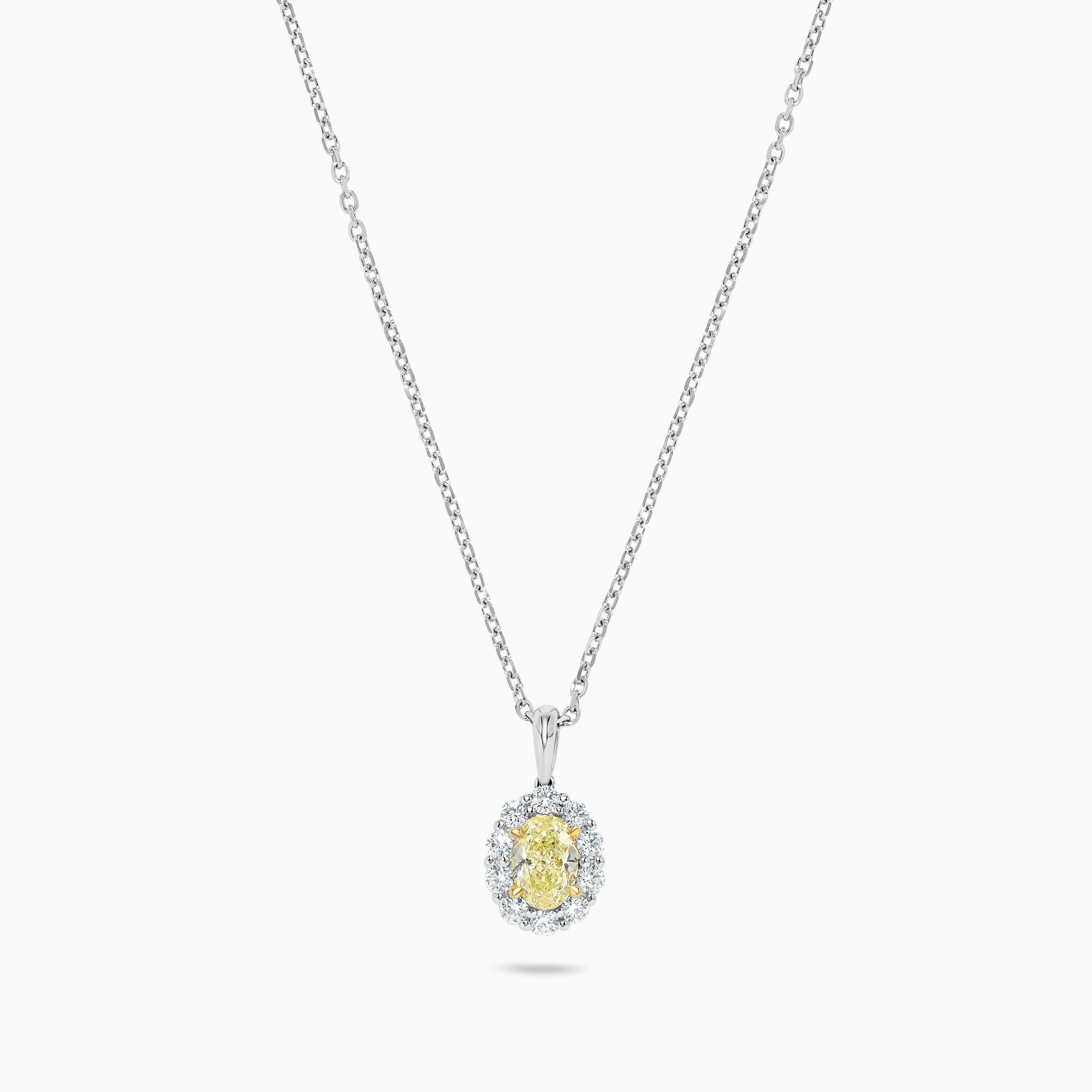 Le pendentif classique en diamant de Raregemworld. Monté dans une belle monture en or jaune et blanc 18 carats avec un diamant jaune naturel de taille ovale. Le diamant jaune est entouré d'une mêlée de diamants blancs ronds naturels. Ce pendentif