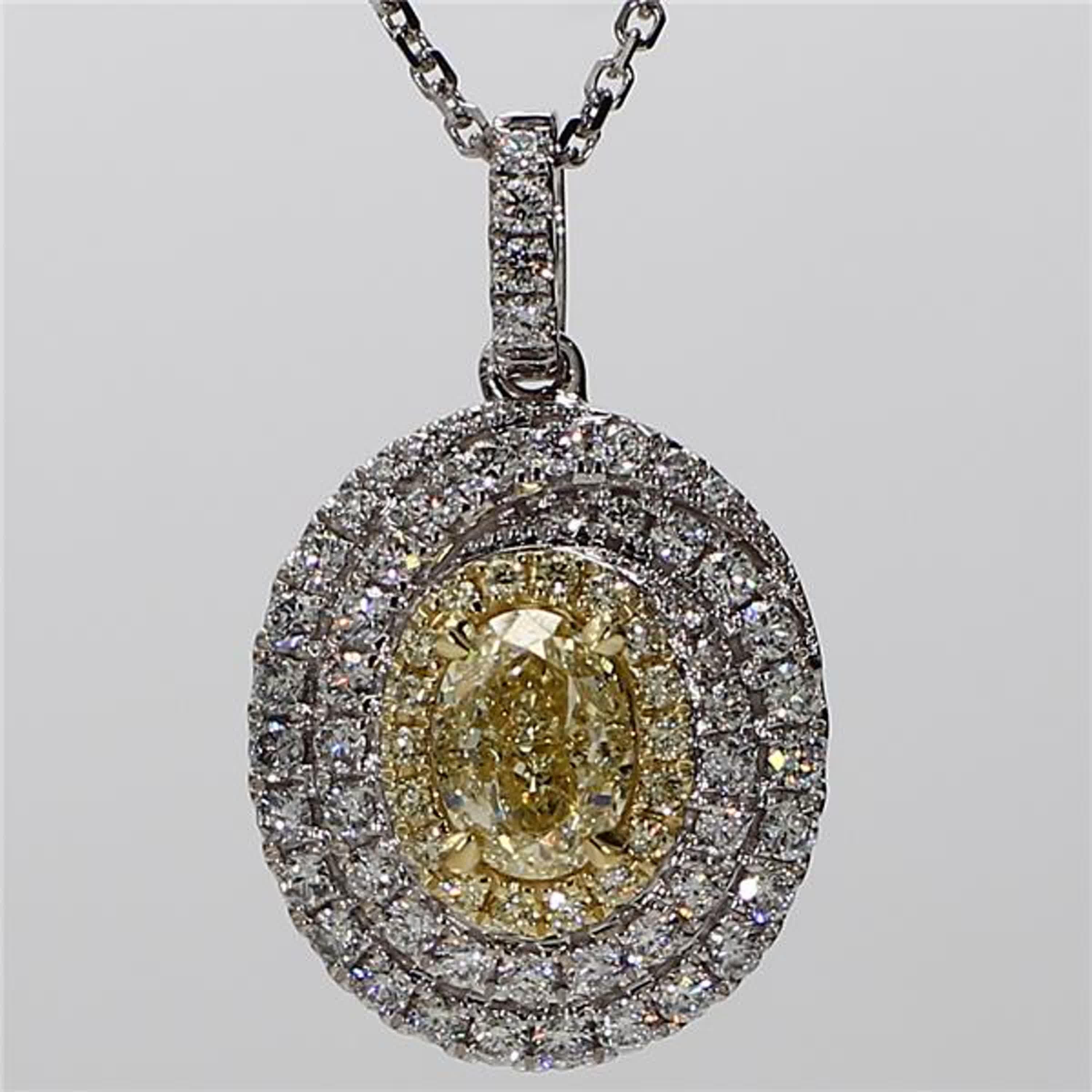 RareGemWorld's classic diamond pendant. Mounted in a beautiful 18K Yellow and White Gold setting with a natural oval cut yellow diamond. The yellow diamond is surrounded by natural round yellow diamond melee and natural round white diamond melee.