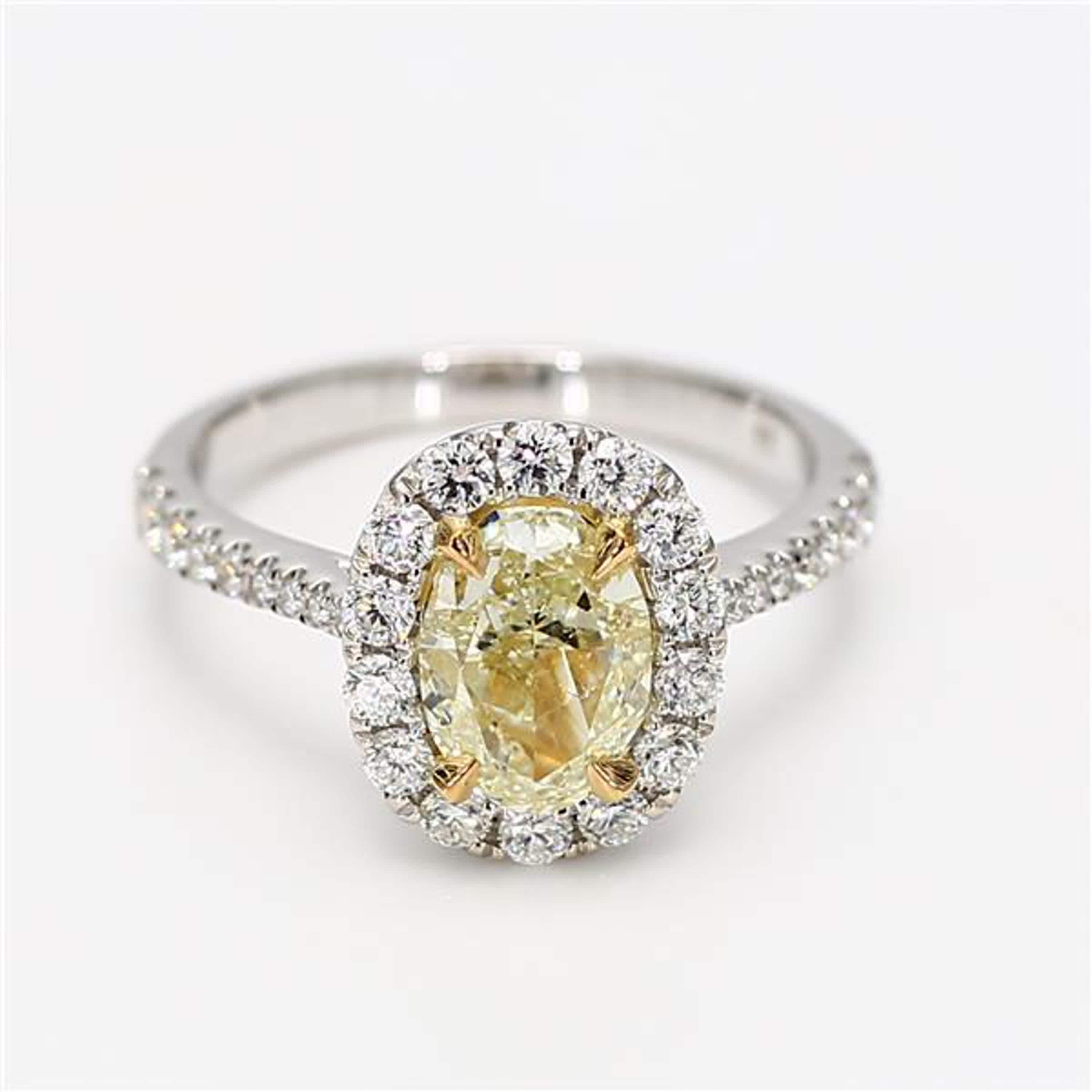 RareGemWorld's classic diamond ring. Mounted in a beautiful 18K Yellow and White Gold setting with a natural oval cut yellow diamond. The yellow diamond is surrounded by round natural white diamond melee. This ring is guaranteed to impress and