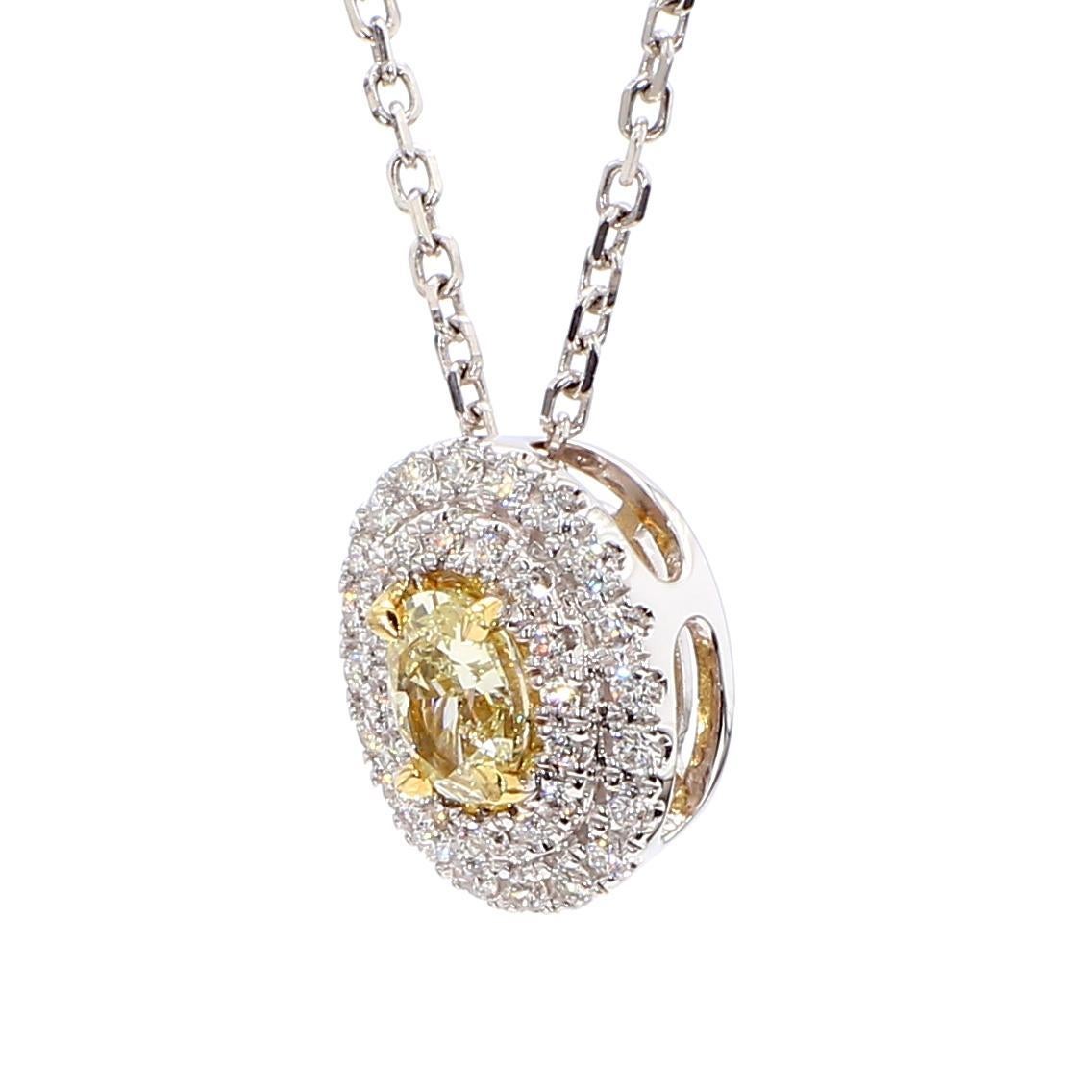 RareGemWorld's classic diamond pendant. Mounted in a beautiful 18K Yellow and White Gold setting with a natural oval cut yellow diamond. The yellow diamond is surrounded by natural round white diamond melee. This pendant is guaranteed to impress and