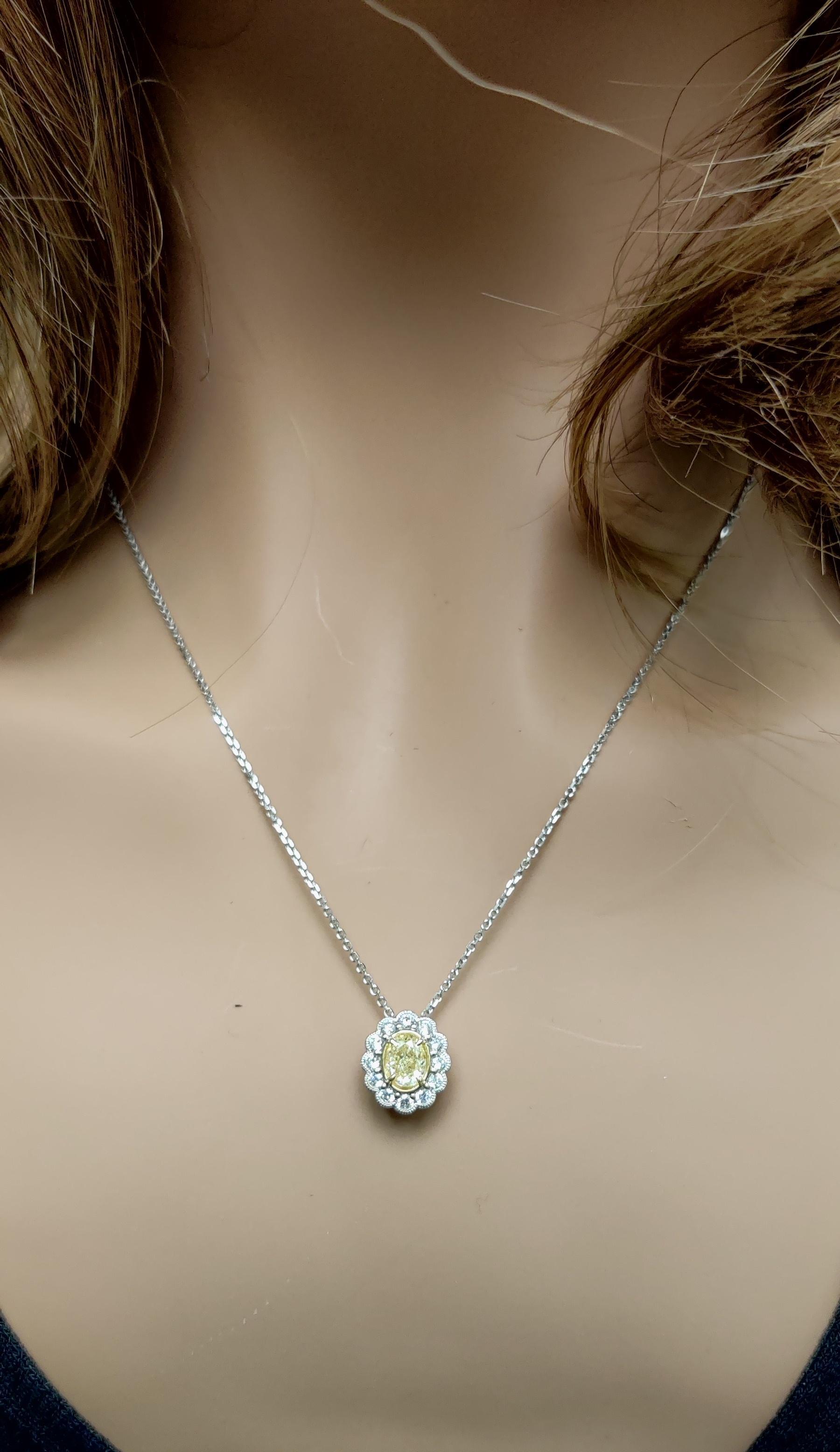 Le pendentif classique en diamant de Raregemworld. Monté dans une belle monture en or jaune et blanc 18 carats avec un diamant jaune naturel de taille ovale. Le diamant jaune est entouré d'une mêlée de diamants blancs ronds naturels. Ce pendentif