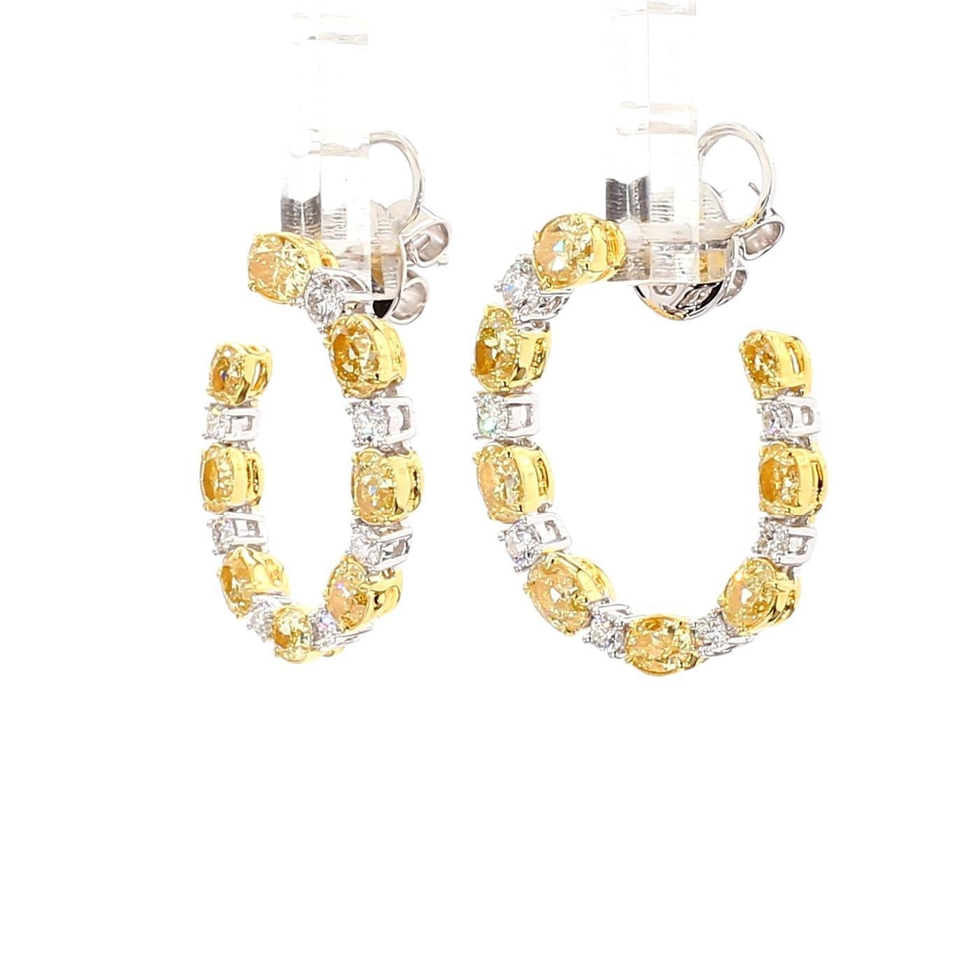 RareGemWorld's schöne Diamant-Ohrringe. Eingefasst in eine wunderschöne Fassung aus 18 Karat Gelb- und Weißgold mit gelben Diamanten im natürlichen Ovalschliff. Die gelben Diamanten sind von runden weißen Naturdiamanten umgeben. Diese Ohrringe