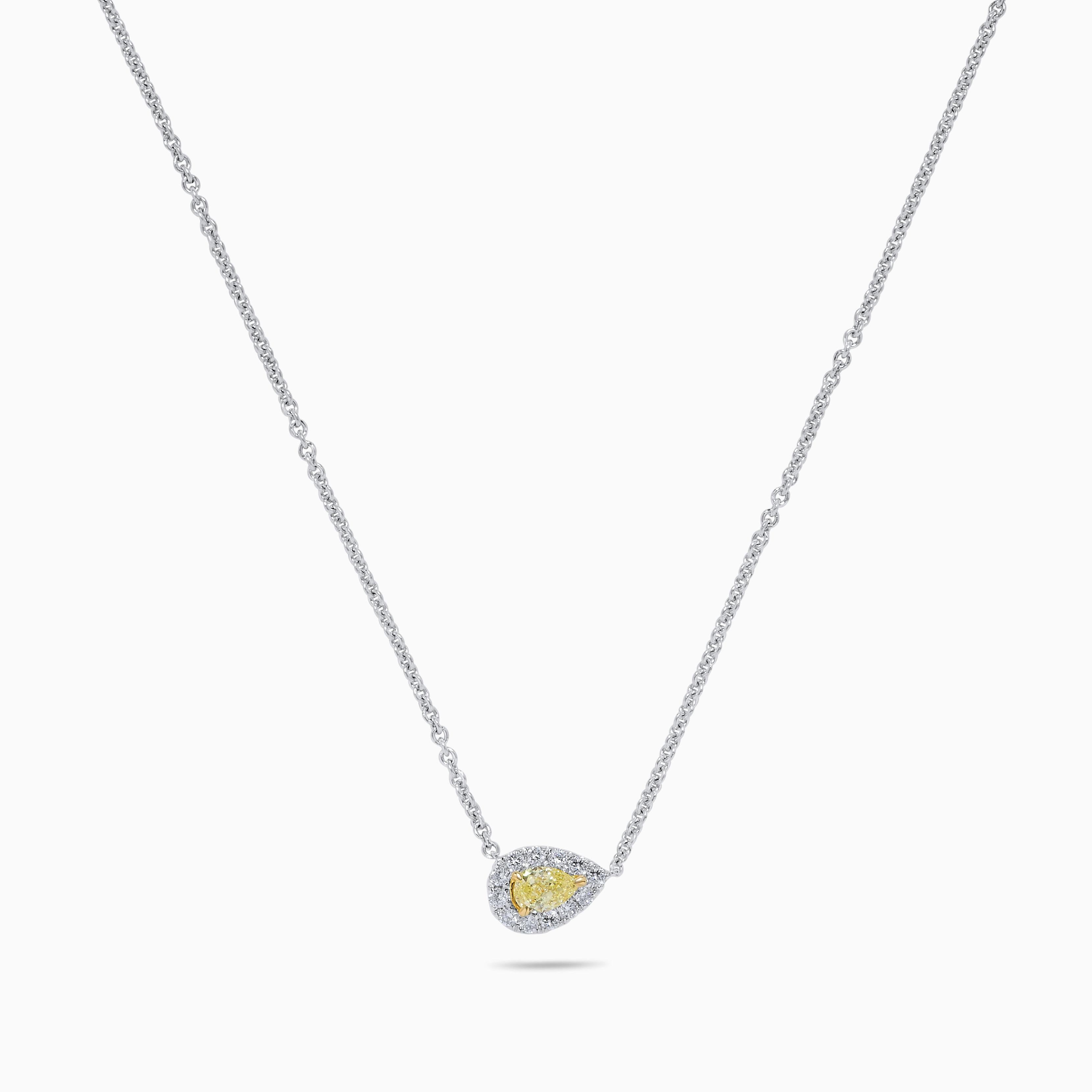 RareGemWorld's classic yellow diamond necklace. Mounted in a beautiful 18K Yellow and White Gold setting with a natural pear cut yellow diamond. The yellow diamond is surrounded by small round natural white diamond melee. This necklace is guaranteed