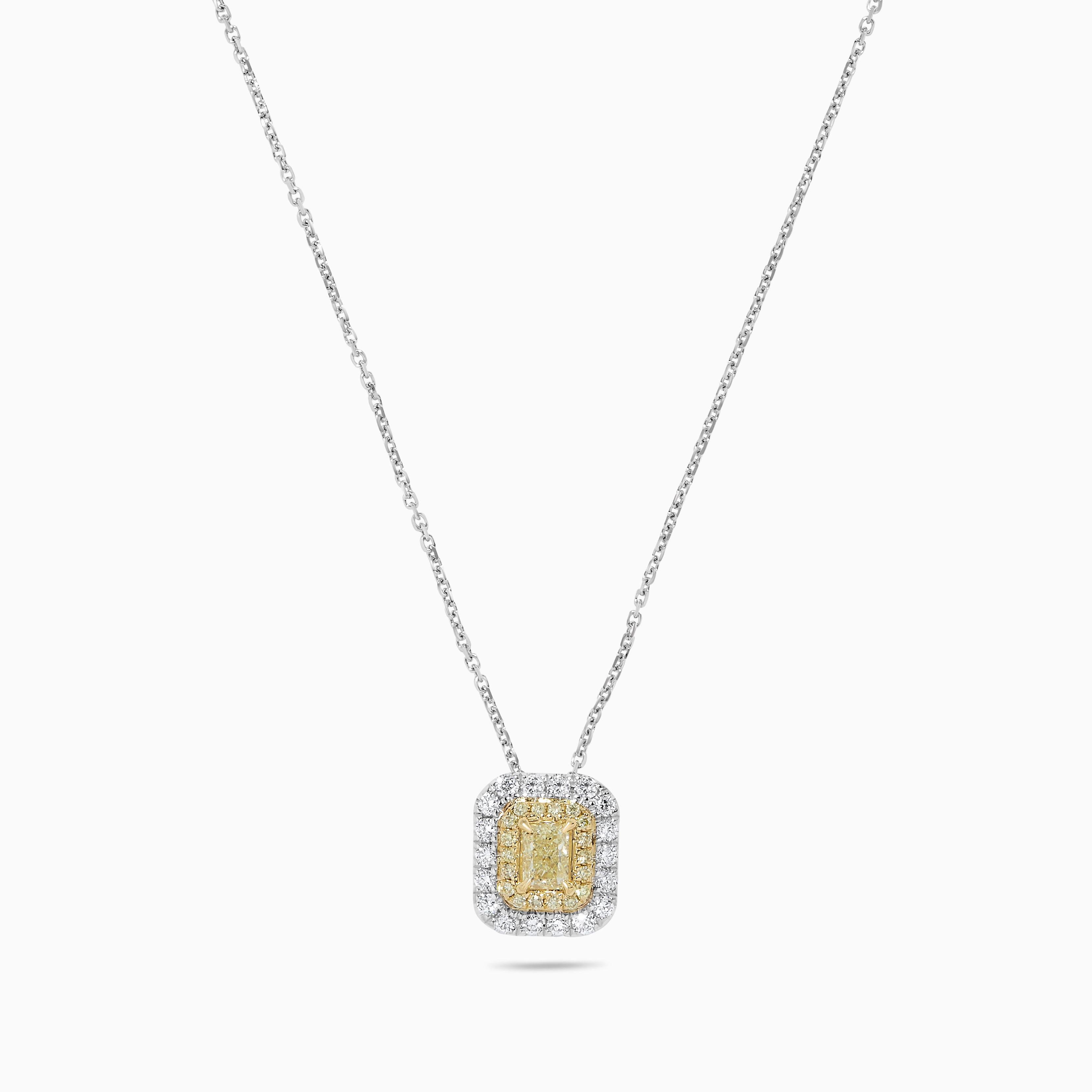 RareGemWorld's classic diamond pendant. Mounted in a beautiful 18K Yellow and White Gold setting with a natural radiant cut yellow diamond. The yellow diamonds are surrounded by round natural white diamond melee and round natural white diamond