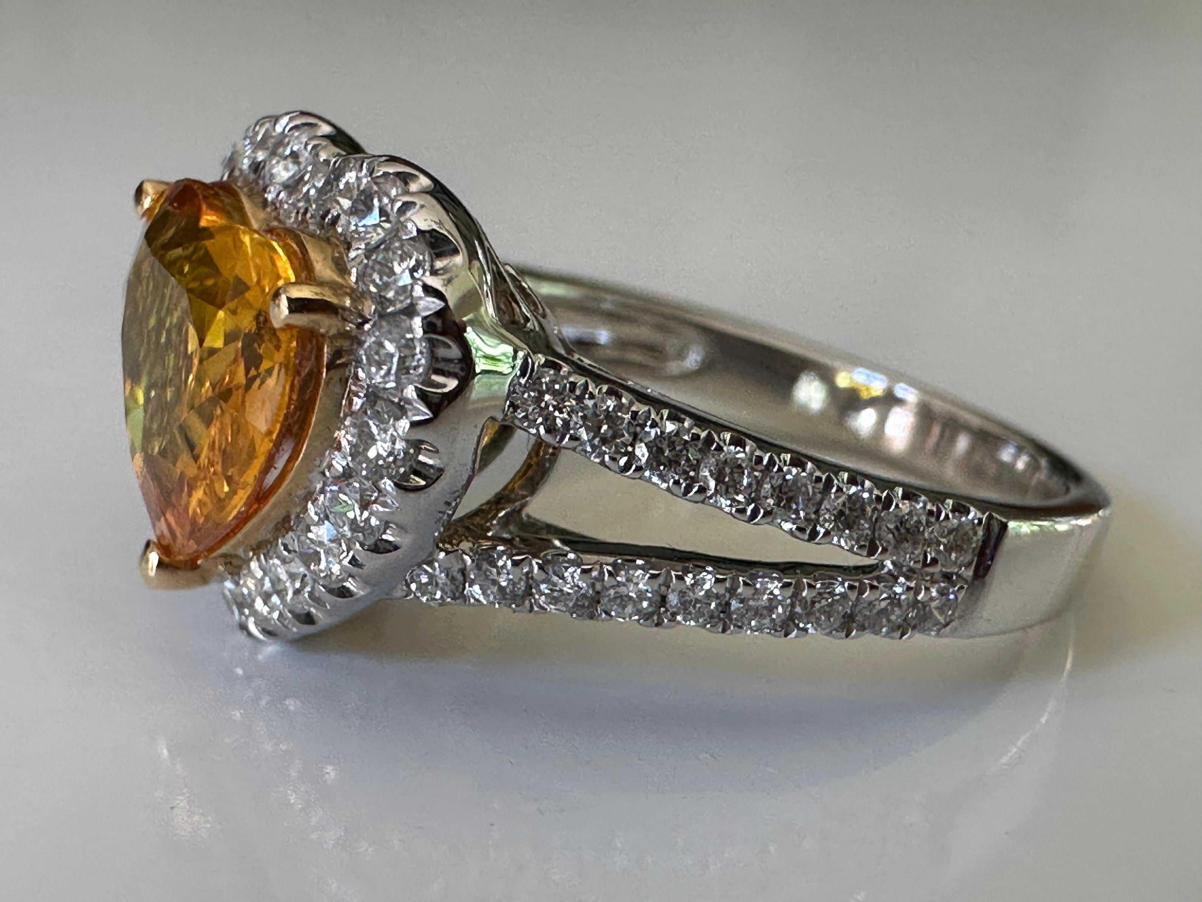 A 2.69-carat natural yellow heart-shaped sapphire from Sri Lanka centers this exquisite ring surrounded by a halo of fifty-four round brilliant-cut diamonds totaling 0.66 carats and accented with a diamond studded split shank. Set in 18k white and