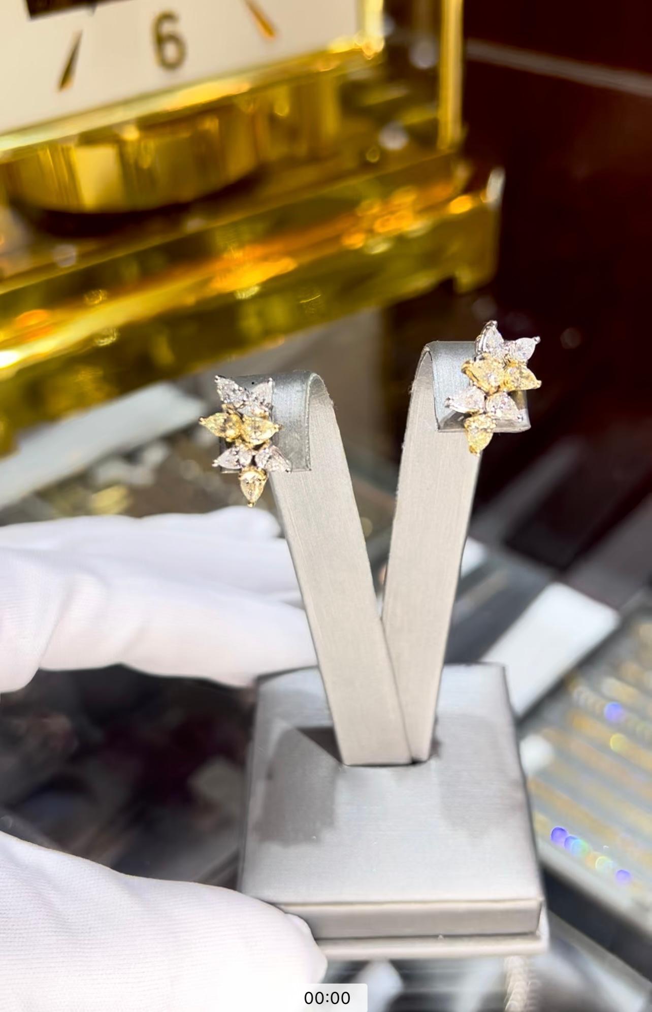 Une superbe paire d'Eleg de style Whiting présentant un mélange de diamants jaunes et blancs de couleur naturelle, élégamment sertis dans de l'or blanc et jaune 18 carats. Entièrement conçues avec des diamants en forme de poire, ces boucles