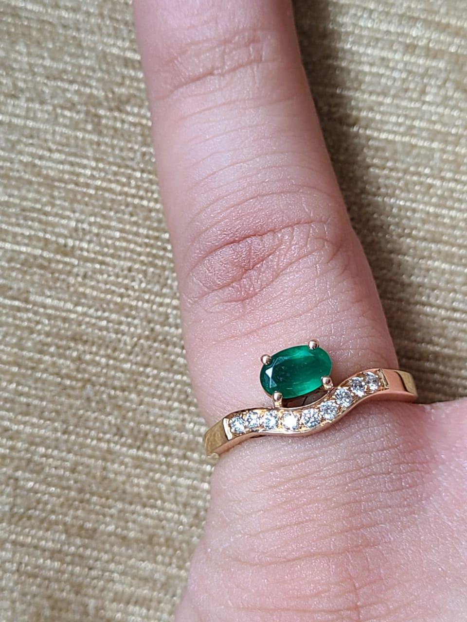 A very dainty and beautiful Emerald Engagement/ Wedding Ring set in 18K Yellow Gold & Diamonds.  The weight of the Emerald is 0.53 carats. The Emerald oval is completely natural, without any treatment & is of Zambian origin. The weight of the