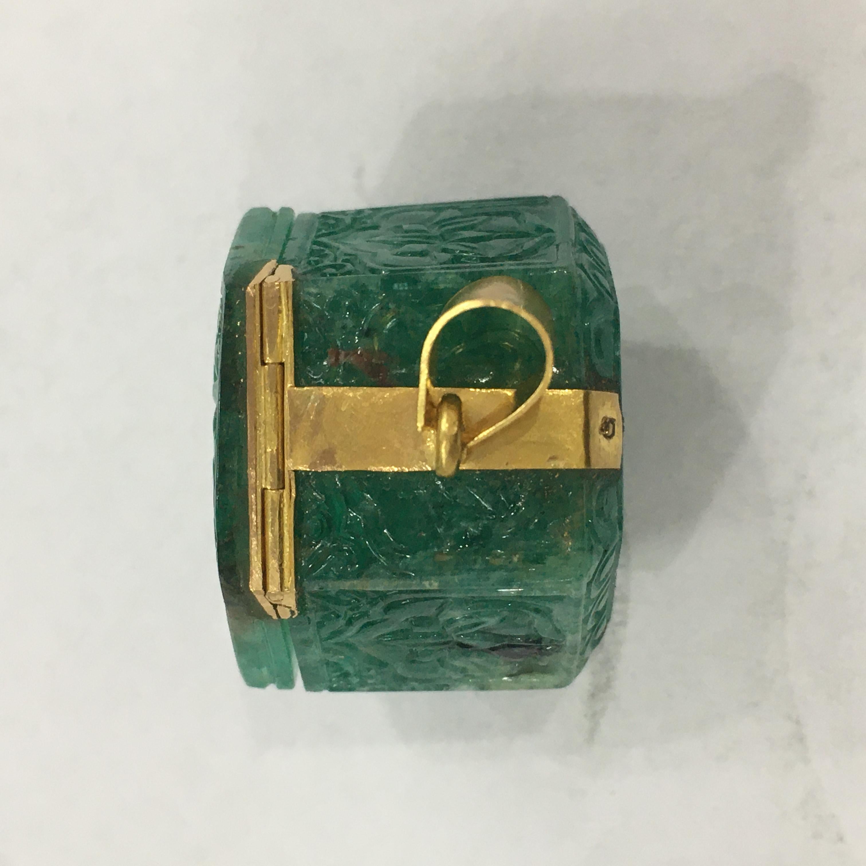 A hexagonal emerald box, made from single piece of 165 ct Zambian emerald setted with 22K yellow gold.

The emerald box of a rich deep green colour and good quality is hand carved on all the sides with floral and poppy motifs. The gold setting is in