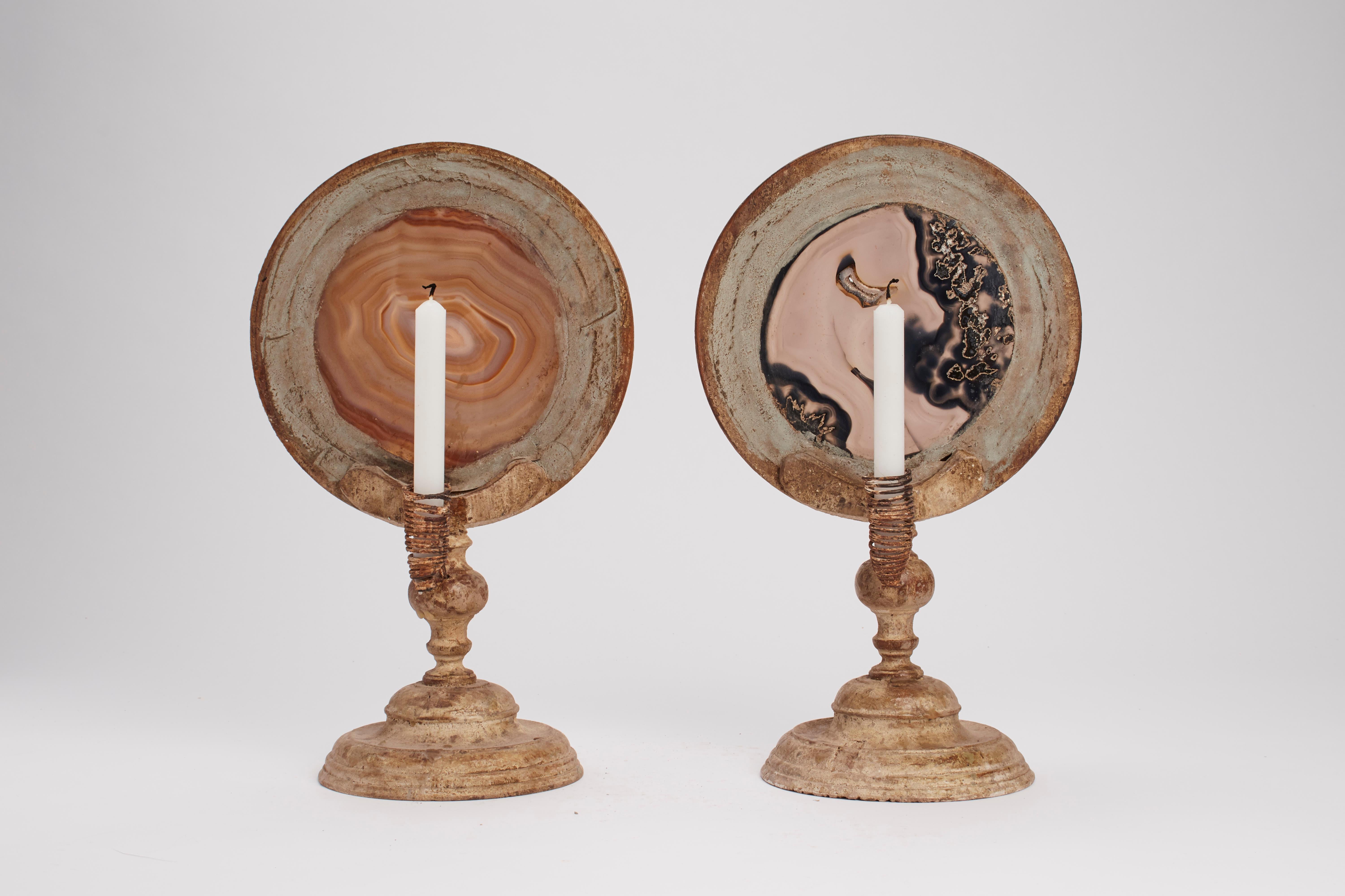 A pair of Wunderkammer naturalia round shape agate specimens with light gray wooden frames, mounted over light gray wooden bases, with candle holders. Italy, 1880 ca.