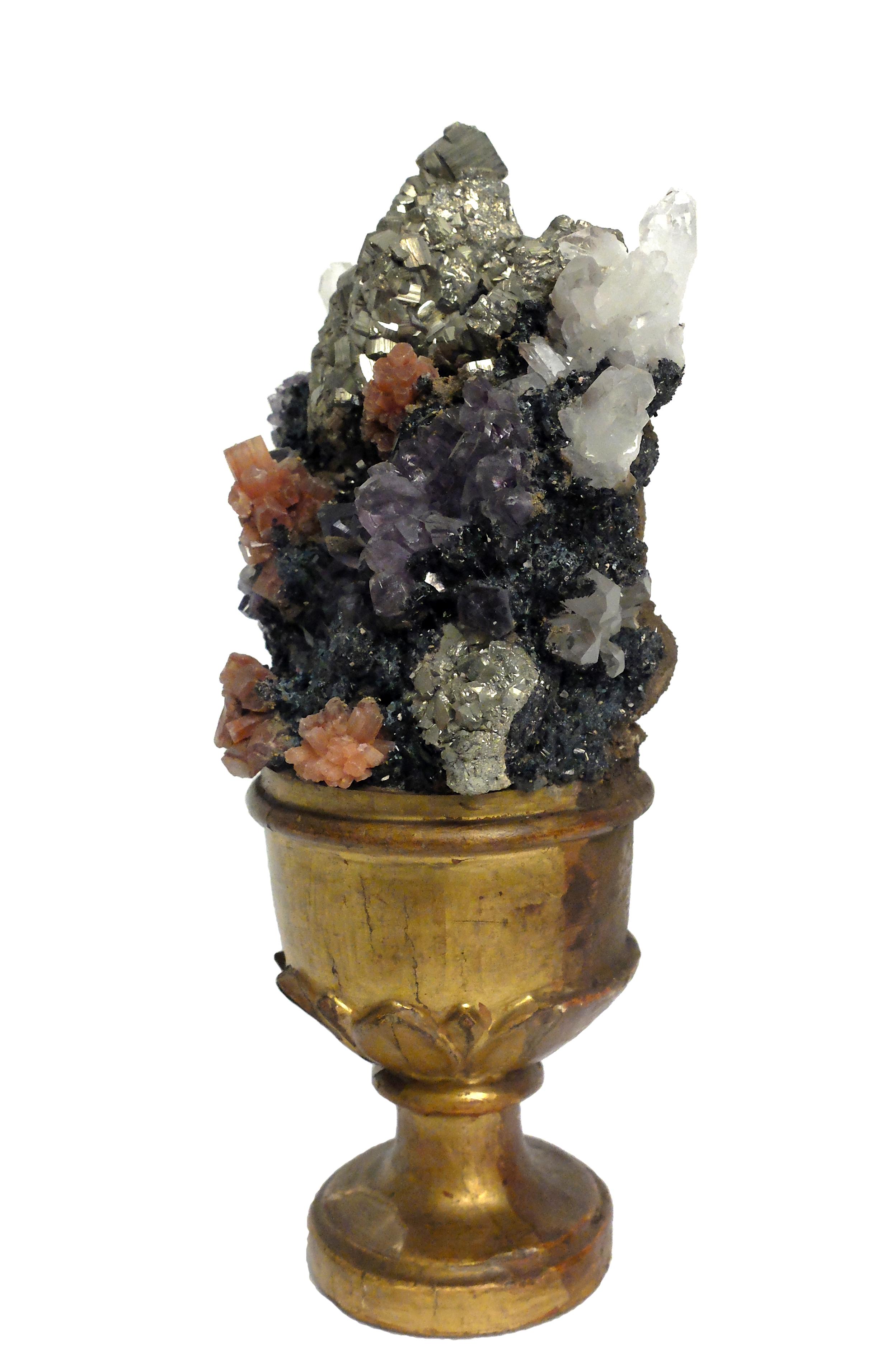A Naturalia mineral specimen: A composition with rock crystal, amethyst, aragonite and pyrite crystals, mounted over a guild plated wooden base on a vase shape, decorated with leaves.