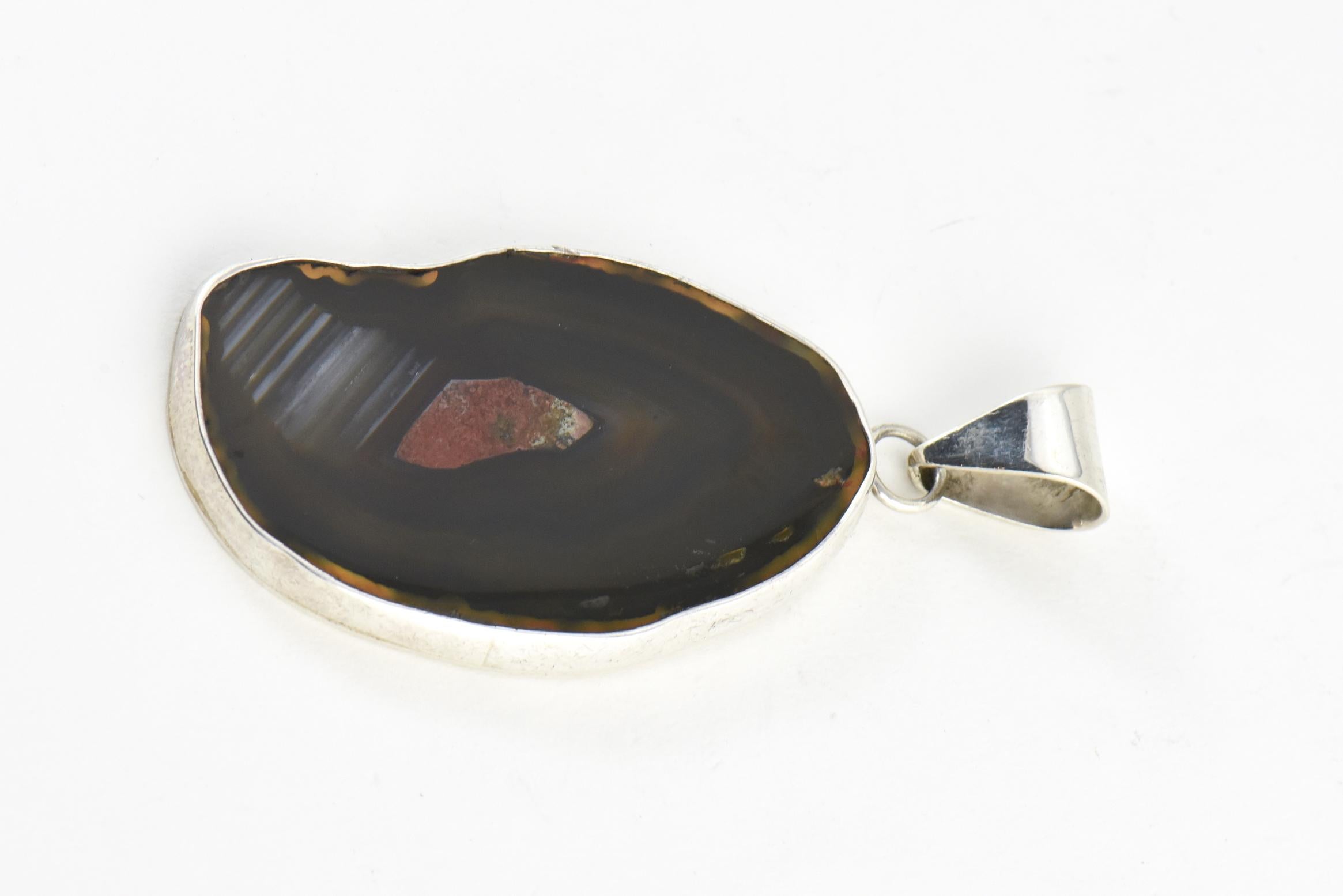 Large brown banded agate pendant mounted in a sterling silver bezel with a large sterling bale. Tested sterling silver - unmarked