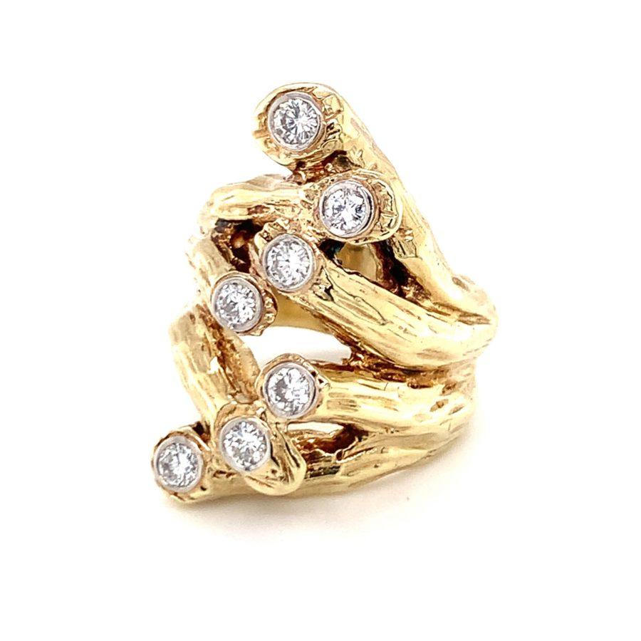 One naturalistic designed diamond ring in 14K yellow gold featuring seven round brilliant cut diamonds totaling approximately 0.75 ct. with H-I color and VS-2 clarity. The ring is enhanced with a textured, branch motif finish with individual