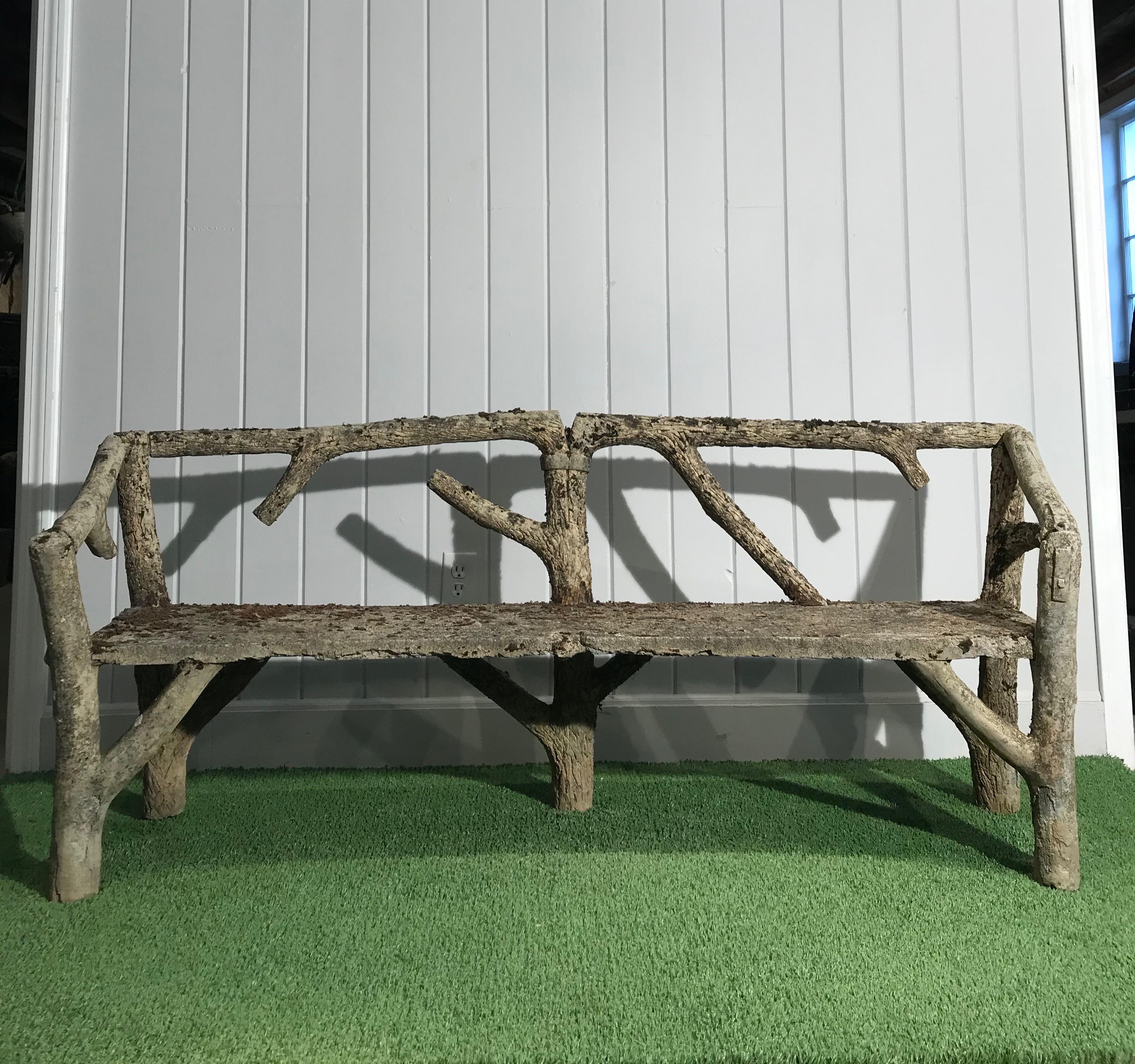 We found this stunning naturalistic and rare faux bois bench in the Normandy region of France and it dates to the 1930s. It has a beautiful weathered patina with mossy patches that will flourish and propagate if the bench is placed in a shady and