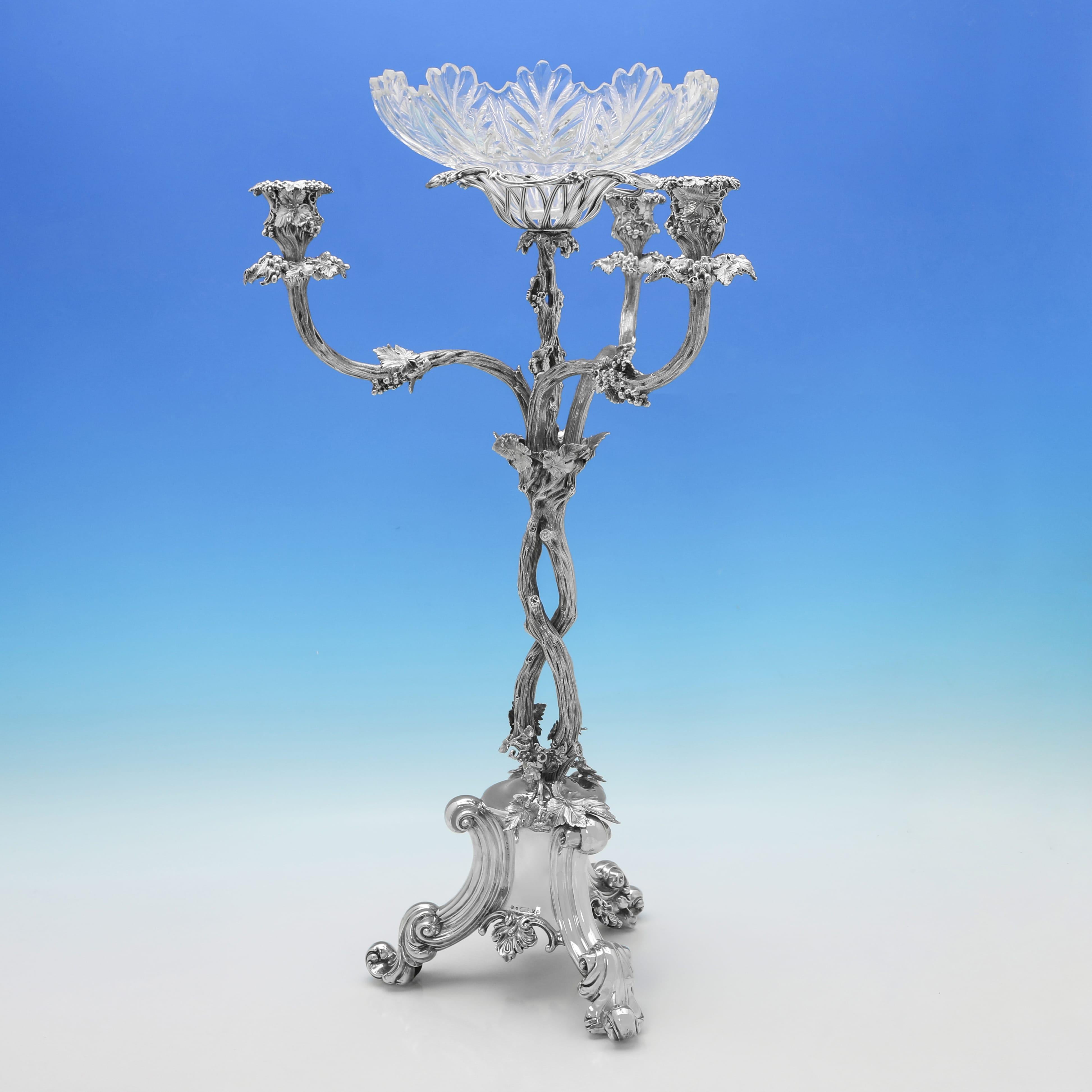 Diese auffällige viktorianische Epergne aus antikem Sterlingsilber, die 1856 in Birmingham von Elkington & Co. gestempelt wurde, ist im naturalistischen Stil gehalten, mit Trauben- und Weindekoration, drei Kerzenhaltern und einer Glasschale in der