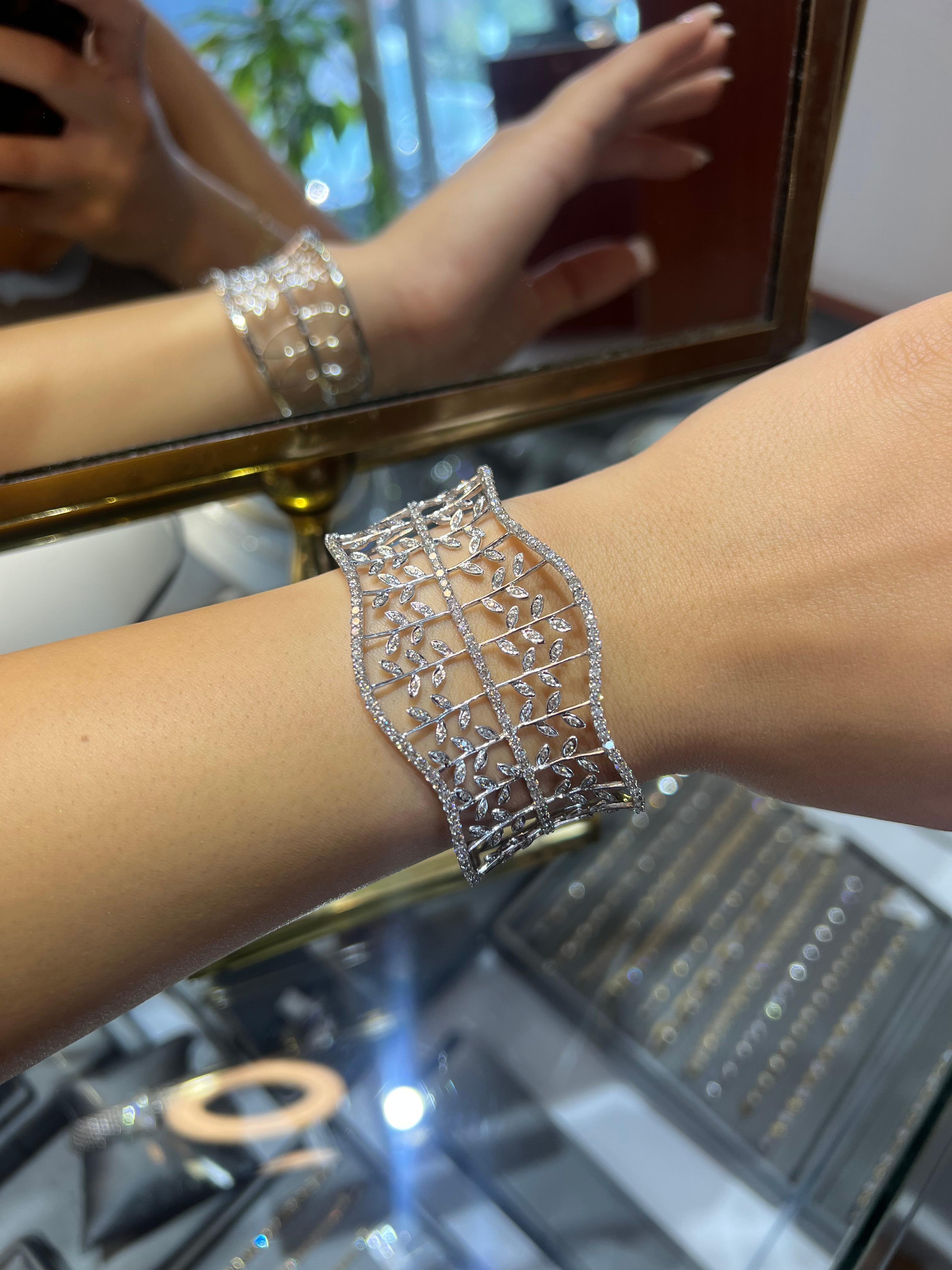 Élevez votre collection de bijoux avec cet extraordinaire bracelet manchette large en diamants, réalisé de main de maître en or blanc lumineux. Avec ses 4,26 carats de diamants ronds et brillants, cette pièce incarne l'élégance intemporelle et la