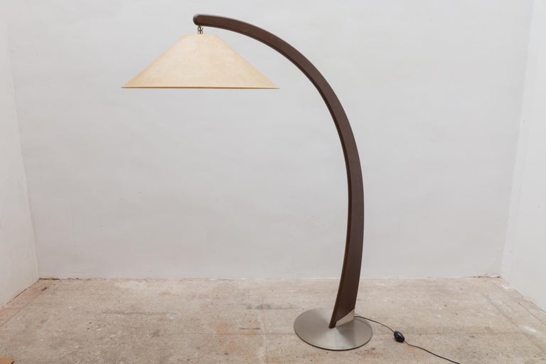 The arch-shaped floor lamp has a modern shape and looks very sophisticated. The frame of wood and nickel floor plate makes this lamp harmonious in combination with the most varied interiors, because this lamp, despite its large size, has a powerful,