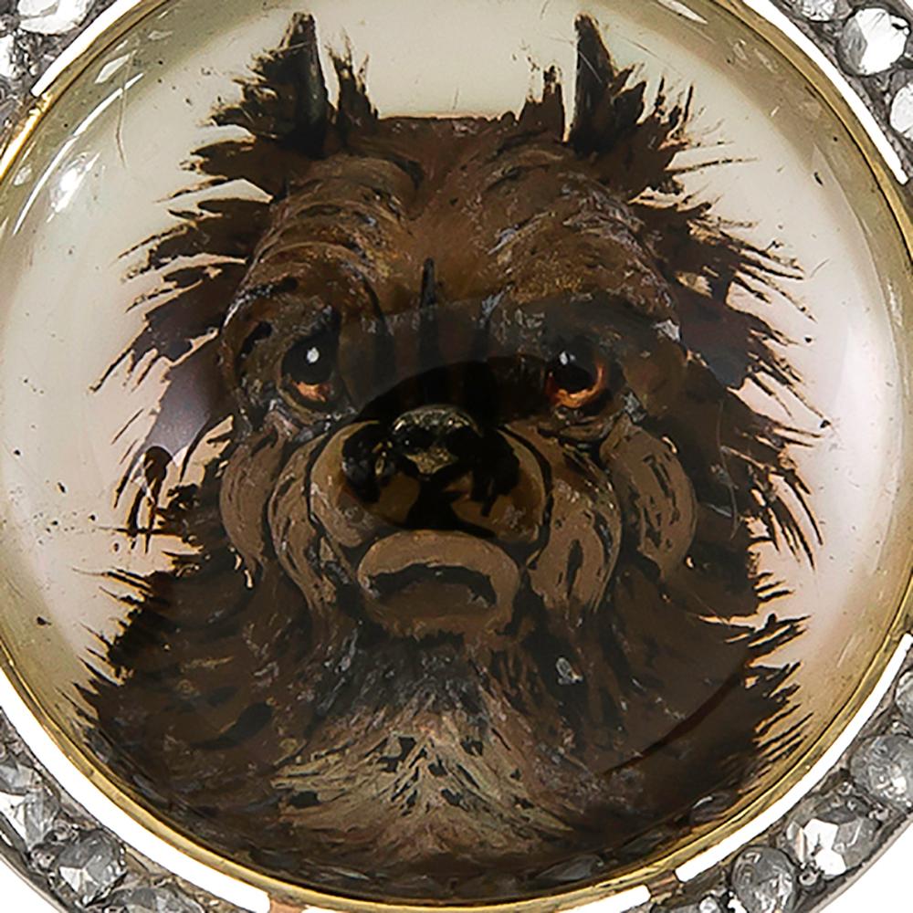 An adorable rendition of a terrier dog, immortalized in reverse painted Essex crystal and framed by rose cut diamonds. The pendant measures just over 1 inch in diameter and is slightly lengthened by the diamond bale. Made of 18k yellow gold and
