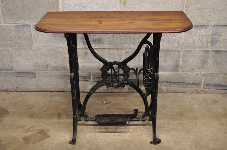 Antique Naumann cast iron Victorian sewing machine base with wood top console small desk. Item features ornate Victorian cast iron sewing machine base with antique wooden top, marked, 