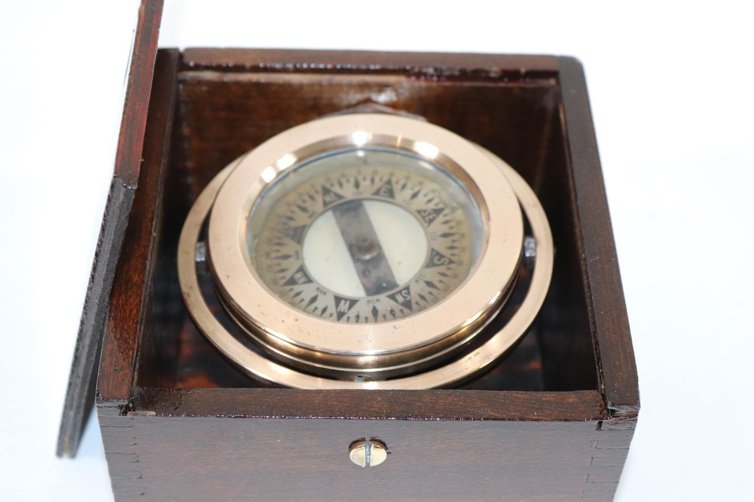 Polished brass boat compass fitted to a dovetailed box with varnish finish. Weight is 2 pounds.
