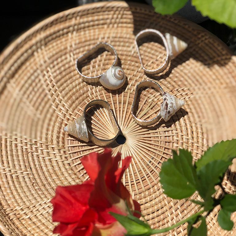 Nautical grotto-style hammered silver napkin rings with shells on top - Set of 4, circa 1970. A great way to create the perfect summer table. Four hammered round or oval napkin rings, with shells affixed to the top. Would also make a great hostess