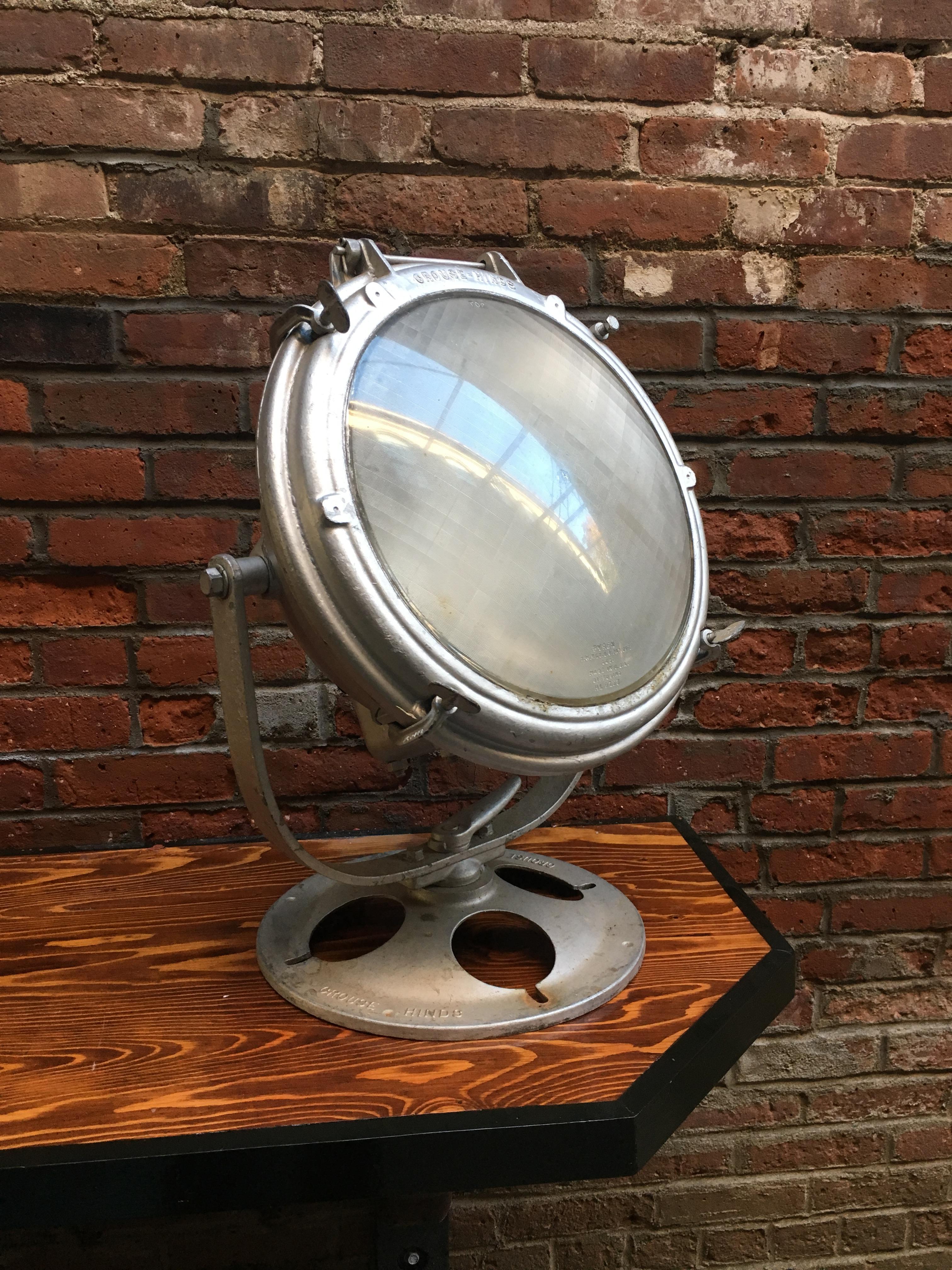 Crouse-Hinds nautical/industrial spotlight. Cast aluminum body and base with glass lens. Fully portable and can be used anywhere. Fully signed. Retains the original extension cord, circa 1940-1950. Good working condition. Old paint metallic paint