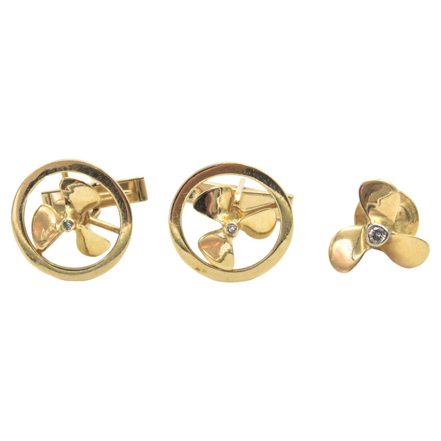 Pair of 14k yellow gold mechanical propeller cufflinks accented with a bezel set diamond in the center.  The propellers on the cufflinks spin.  The cufflinks are easy to put on with a simply 