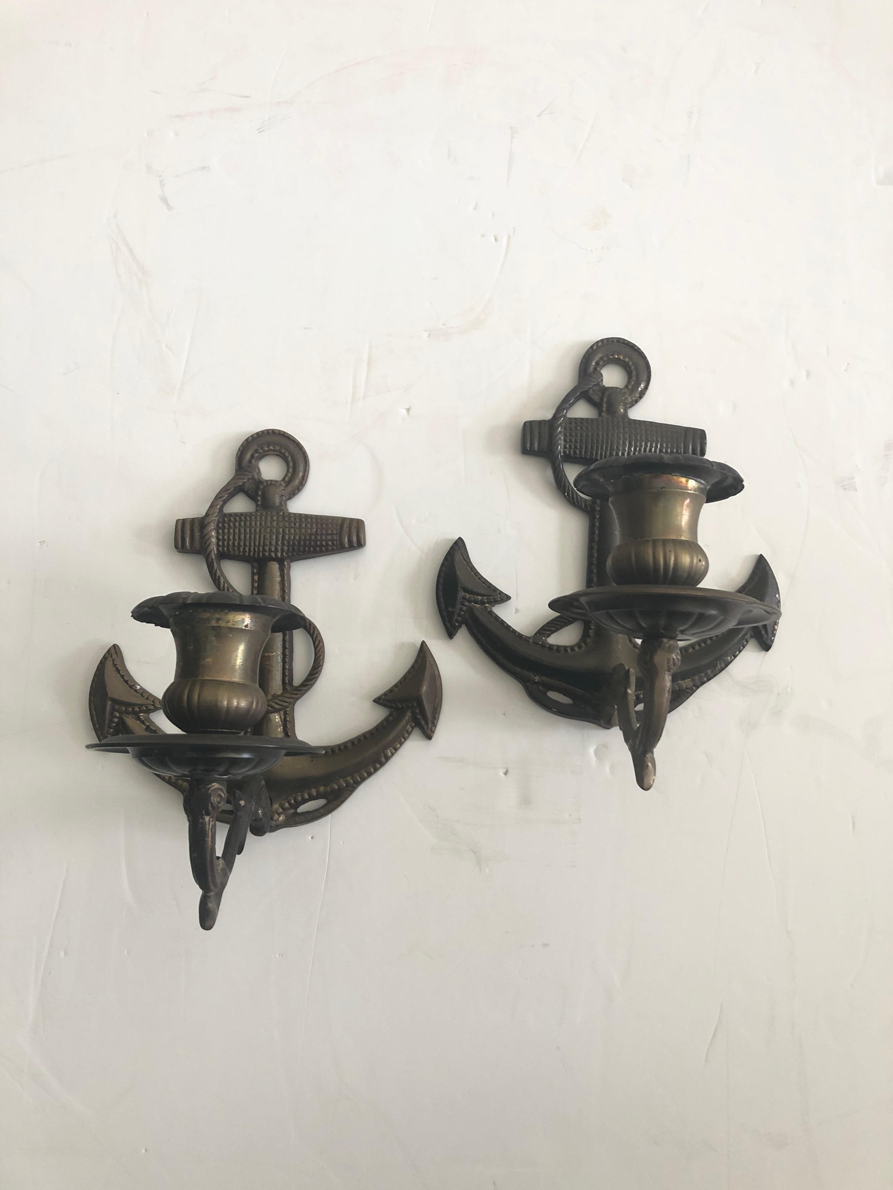 A fun pair of aged brass candle sconces having an anchor nautical motife.