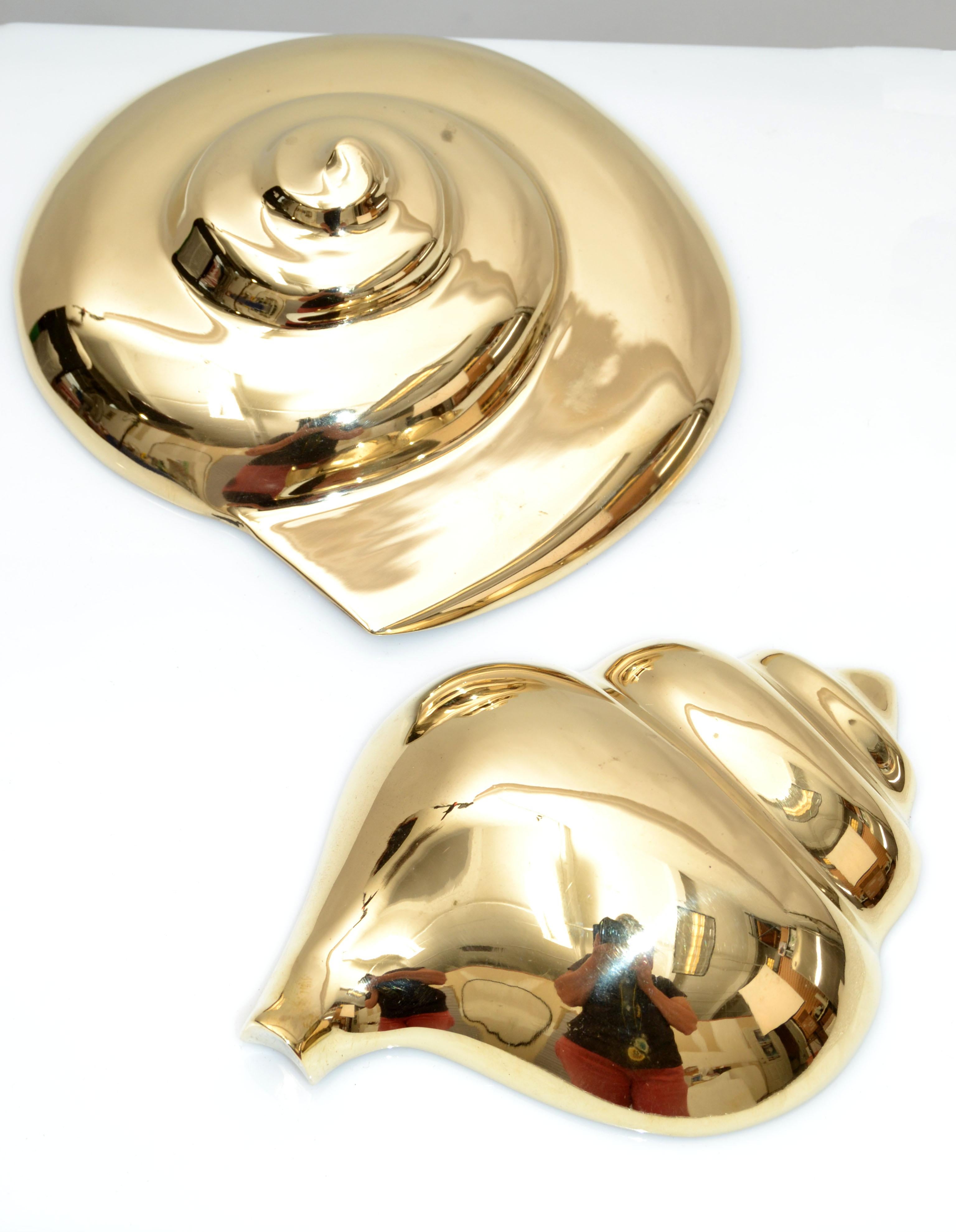 Mid-Century Modern 2 Pieces Nautical polished brass seashell sculptures wall art. 
Have a Hook in the reverse for secure hanging.
Round Shell measures: Height: 3 inches x 6.75 inches Diameter.