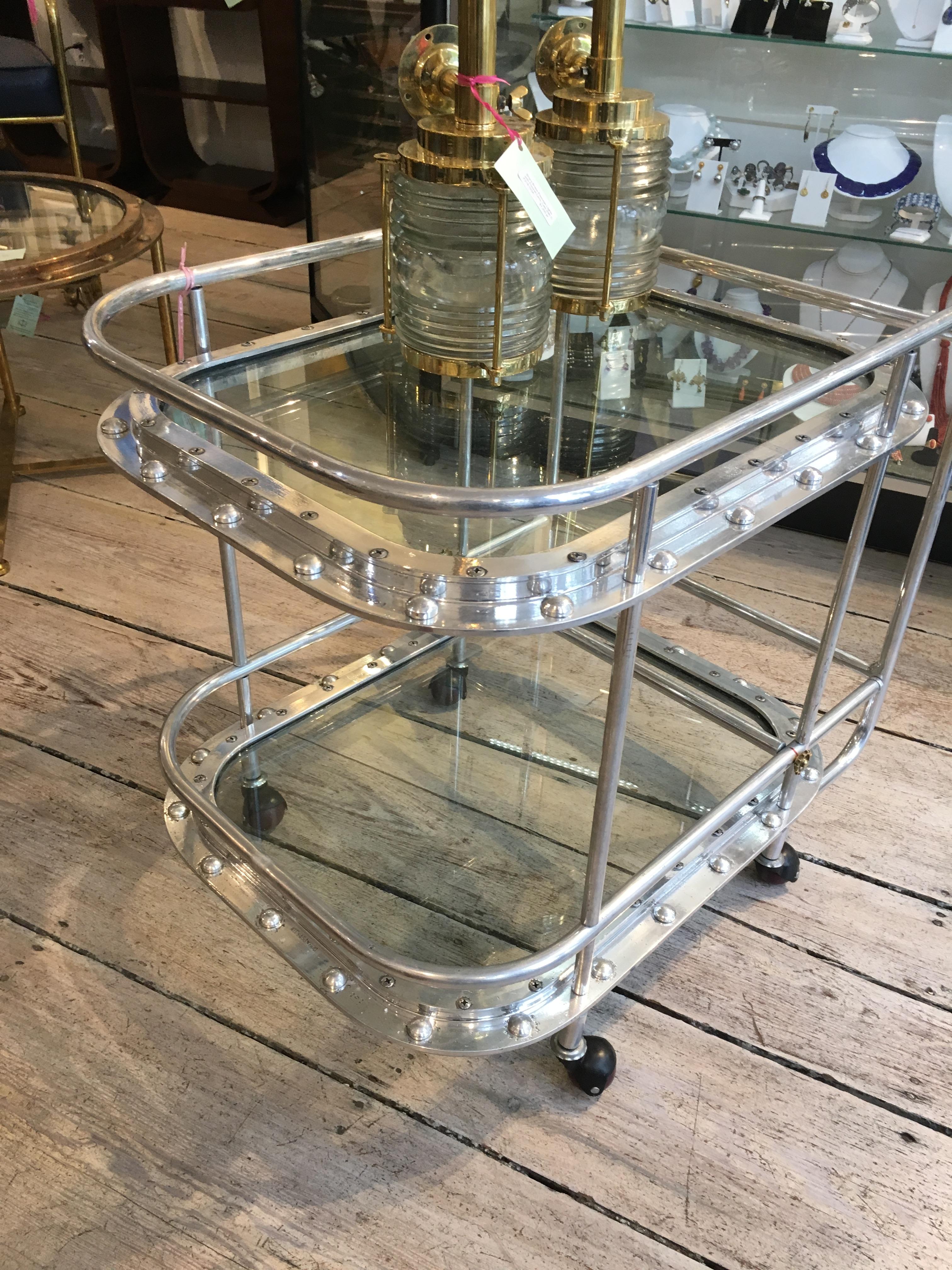 A bespoke piece, using two original 1970s chrome porthole windows with new rivets put back in (the original rivets pop out when ship's are dismantled), and then fashioned into a bar cart. Full round wheels make for easy manoeuvrability. 16 inches
