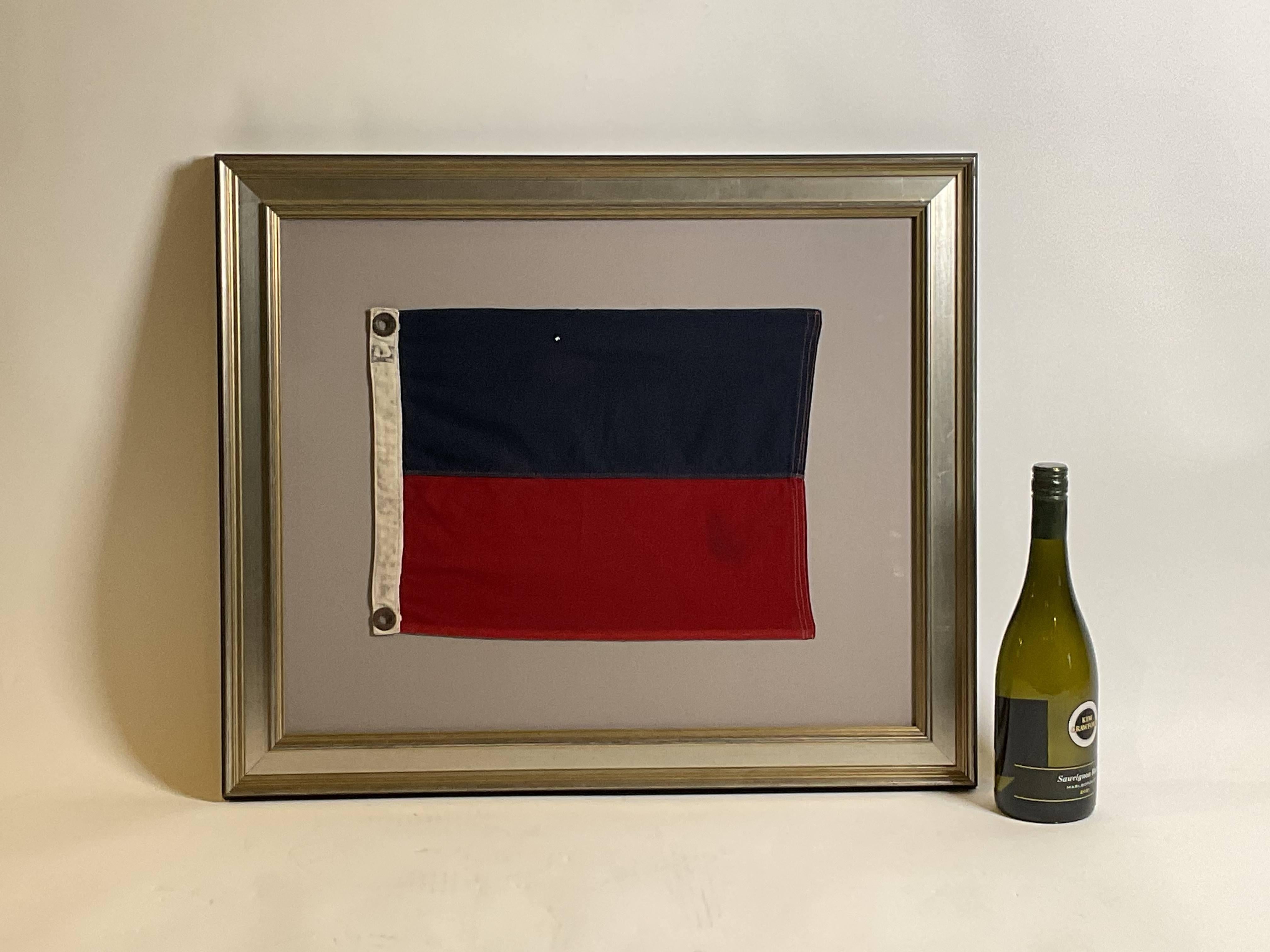 Vintage maritime signal flag signifying letter “E”, echo. Stitched in panels of red and blue. Canvas hoist with brass grommets and the letter “E” in black ink, set into a custom frame.

Weight: 6 lbs.
Overall Dimensions: 22