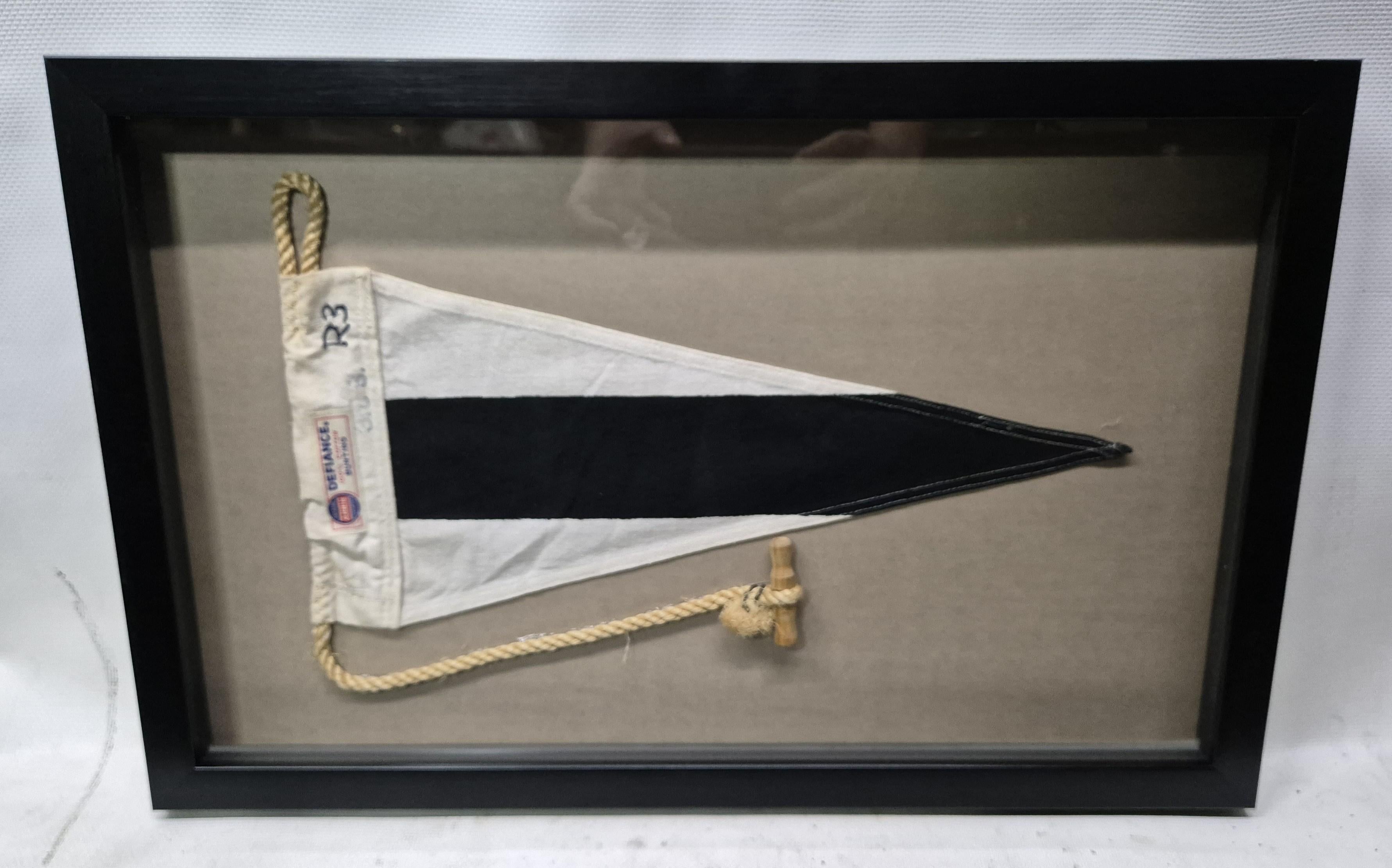 Genuine international maritime signal flag in a custom shadowbox frame. The cotton flag represents the substitute flag R3. The pennant has a white canvas hoist with a sisal rope and wood toggle, with an attached maker's label from 'Annin,' the