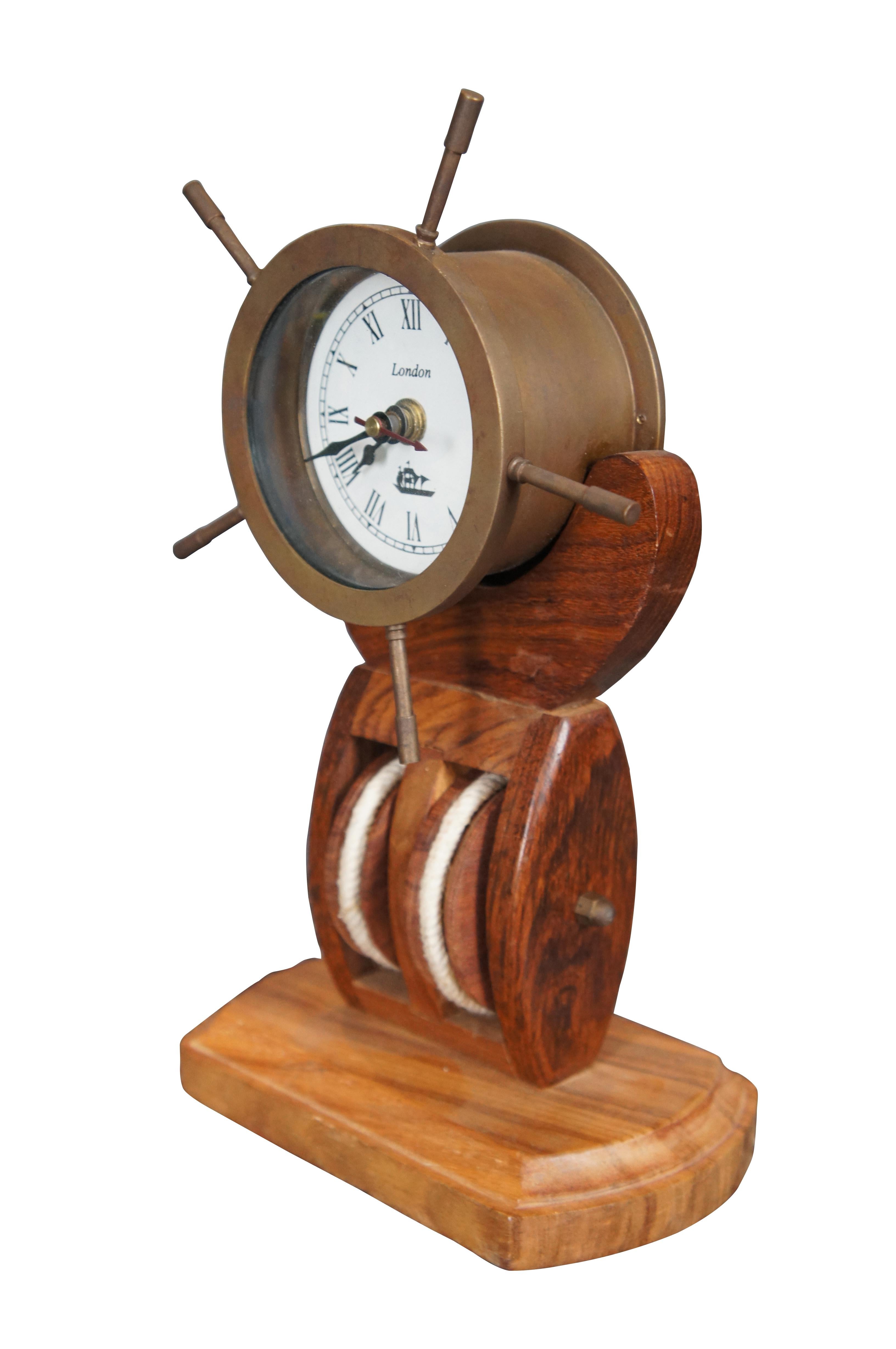 Brass ships wheel clock over wooden pulley. Clock face marked London.

Dimensions:
7