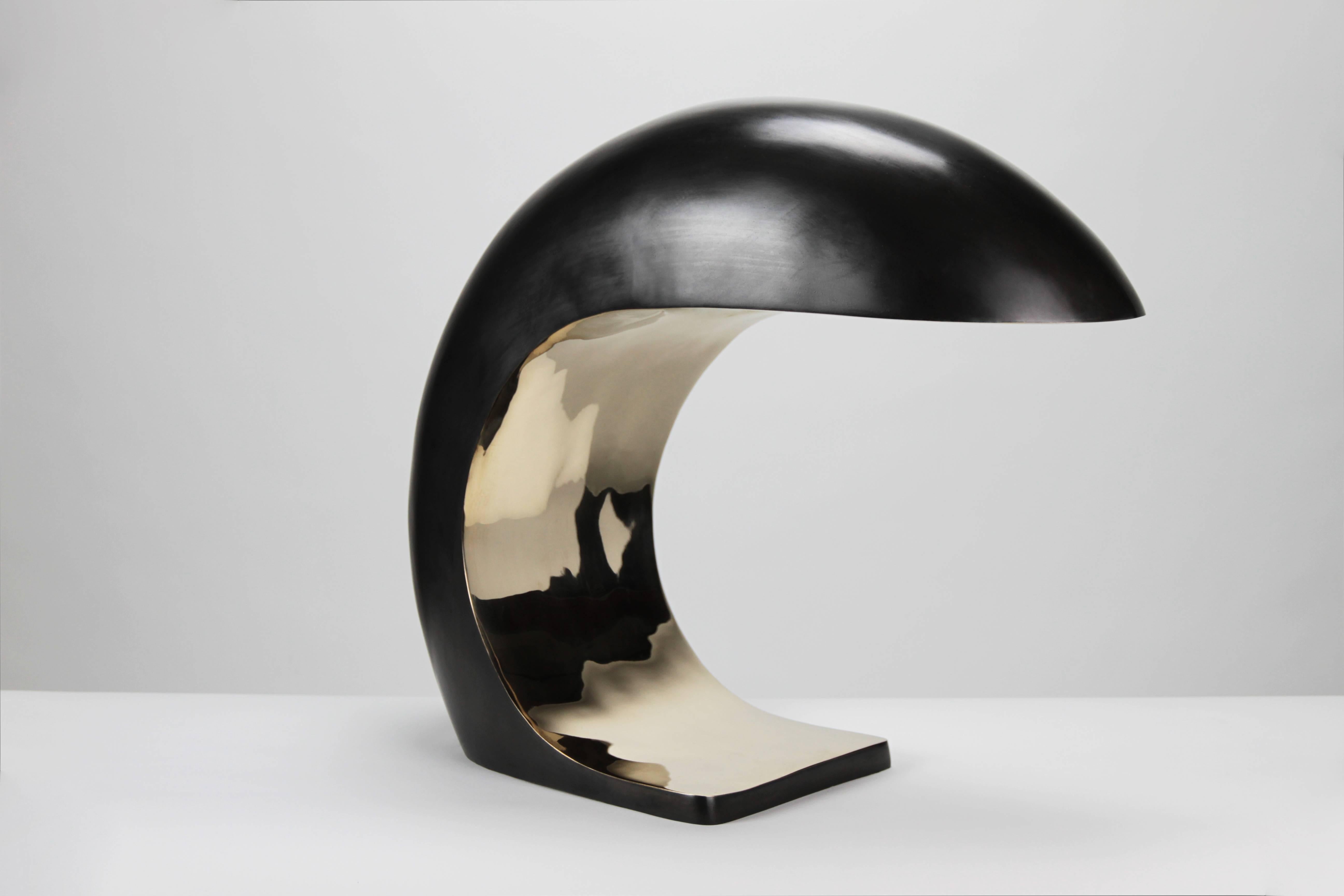 The NAUTILUS lamp is inspired by midcentury Italian design.
It is cast bronze and weighs up to 28 pounds. The outer shell has a blackened patina and the face is high polished to a mirrored finish.
 
The NAUTILUS illuminates by a three-way touch