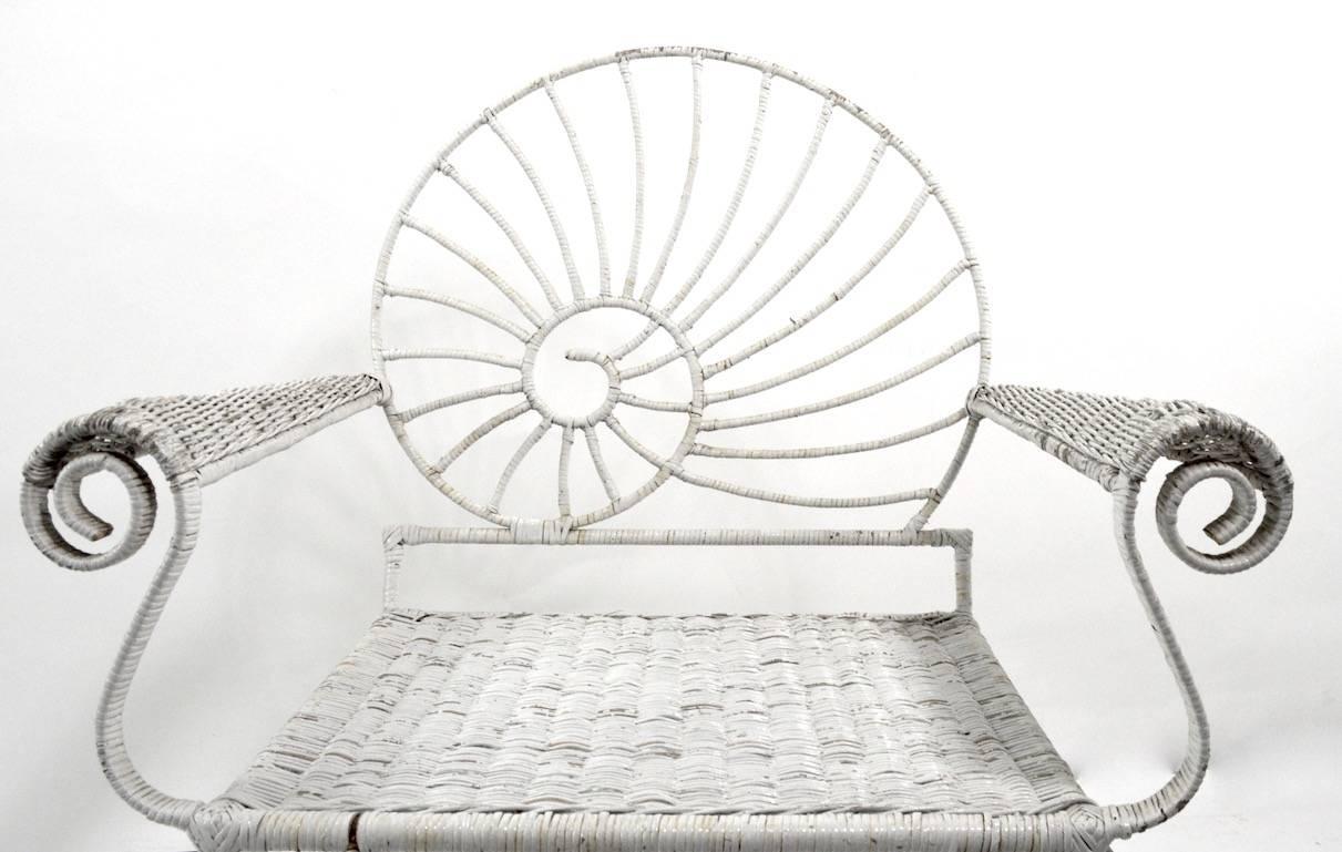 Iron and wicker Nautilus Shell back lounge chair. This chair has a wicker wrapped iron frame, the wicker wrapping show some minor loss, and the paint finish shows wear, structurally sound. Seat H 15 x Arm H 25 inches. 
 Please view the matching