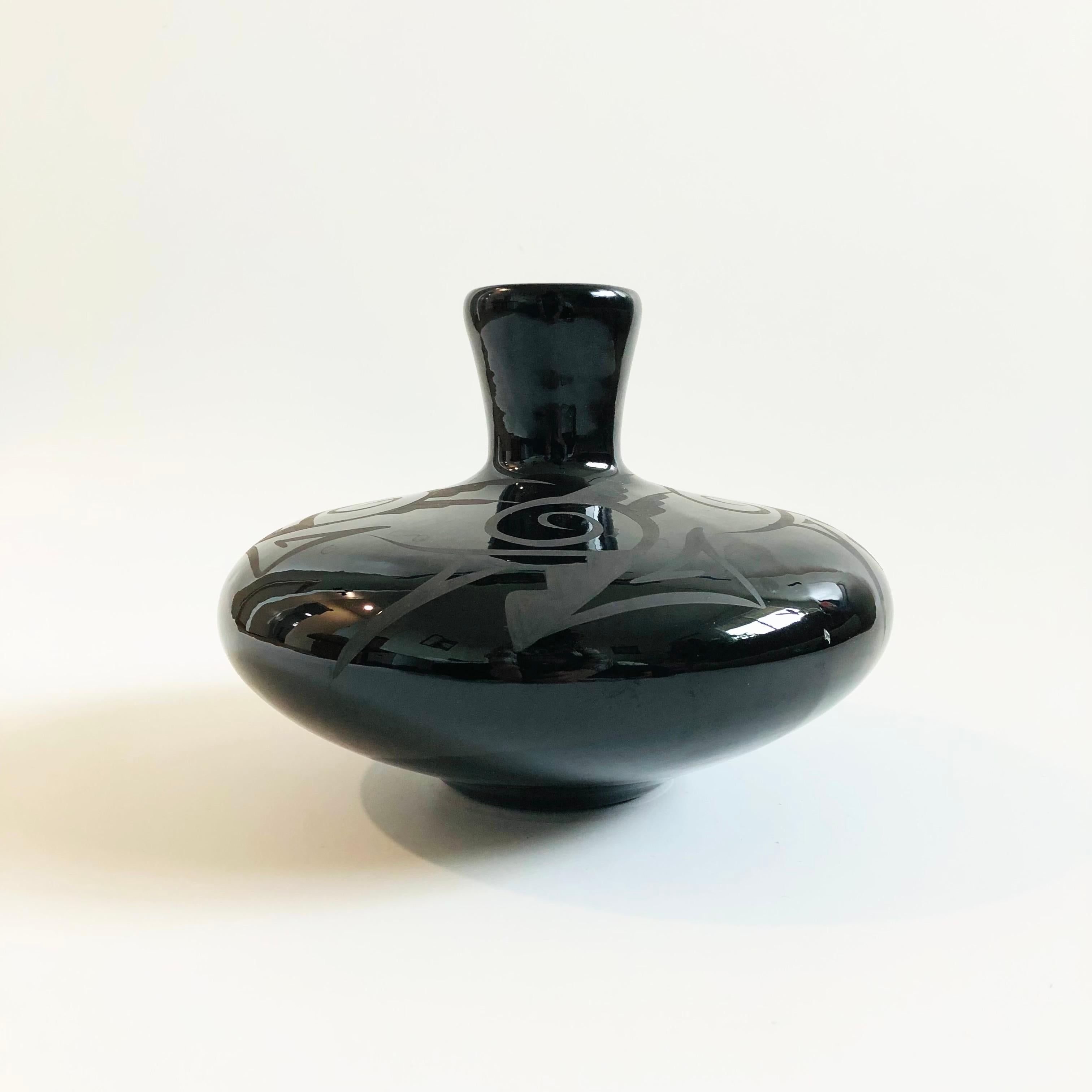 A beautiful vintage Navajo black pottery vase. Glossy black glaze with a hand painted matte black design around the sides. Marked 